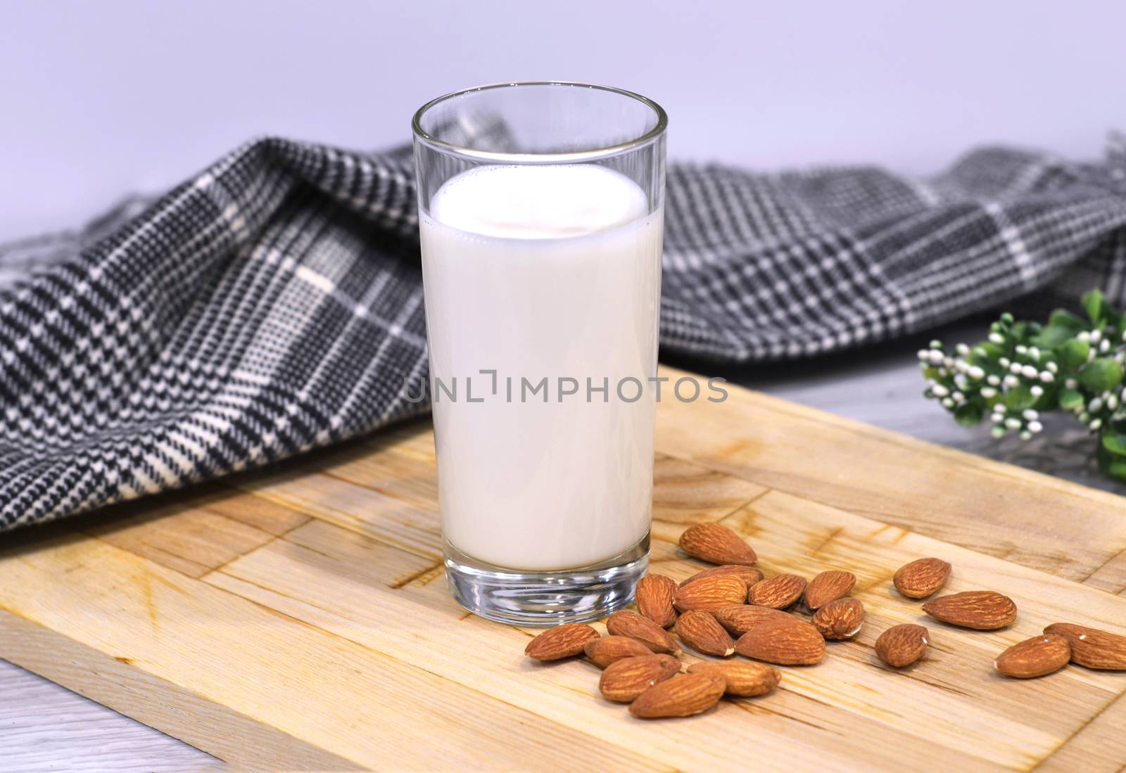 Almond milk with almond on a wooden table.