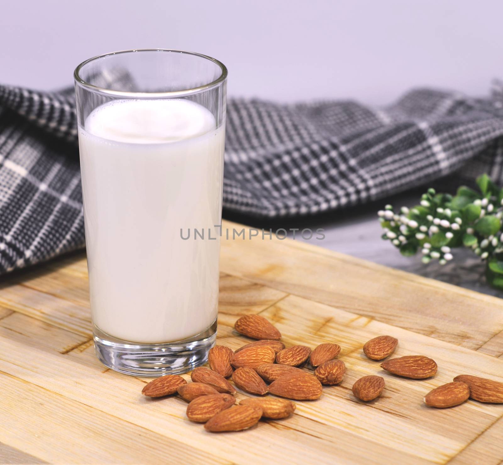 Almond milk with almond on a wooden table.