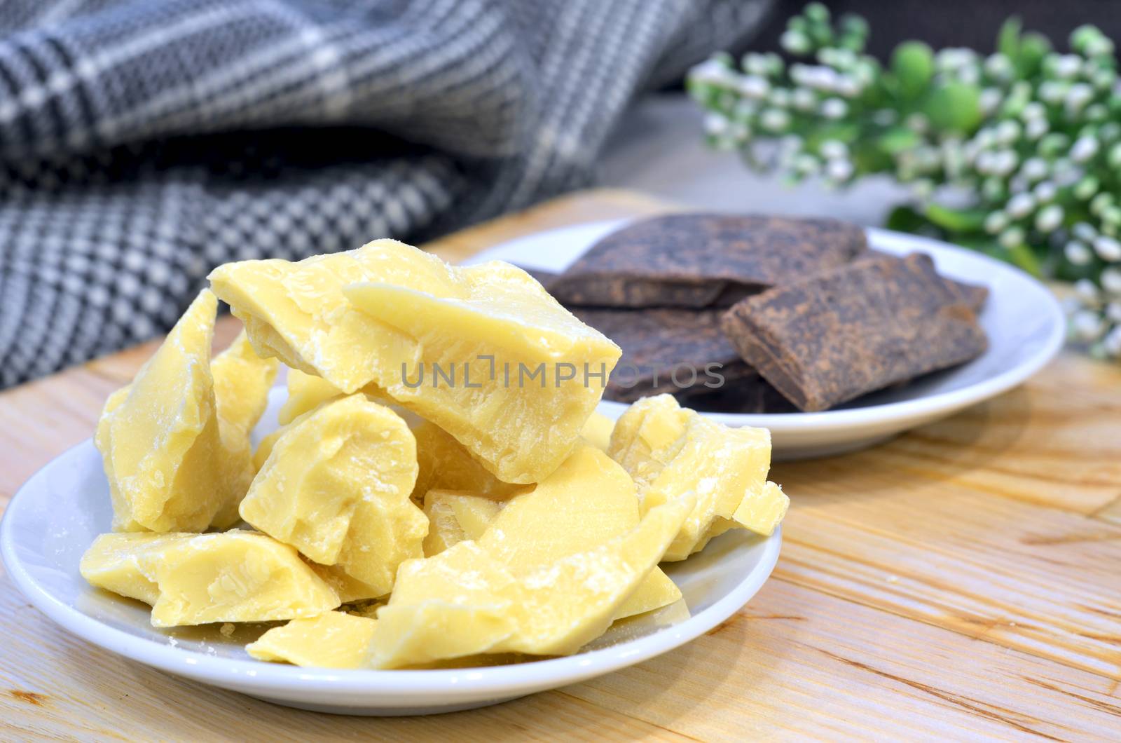 Natural cocoa butter oil in a wooden bowl on a brown background.