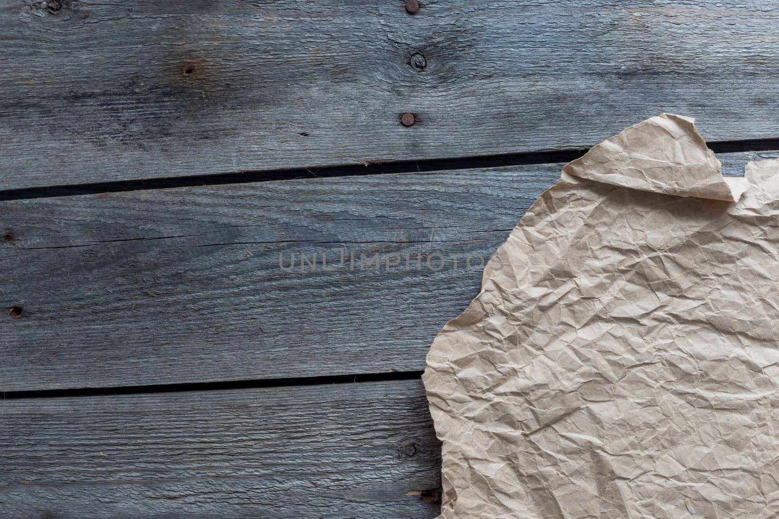 Crumpled craft paper on wooden background, copy space.