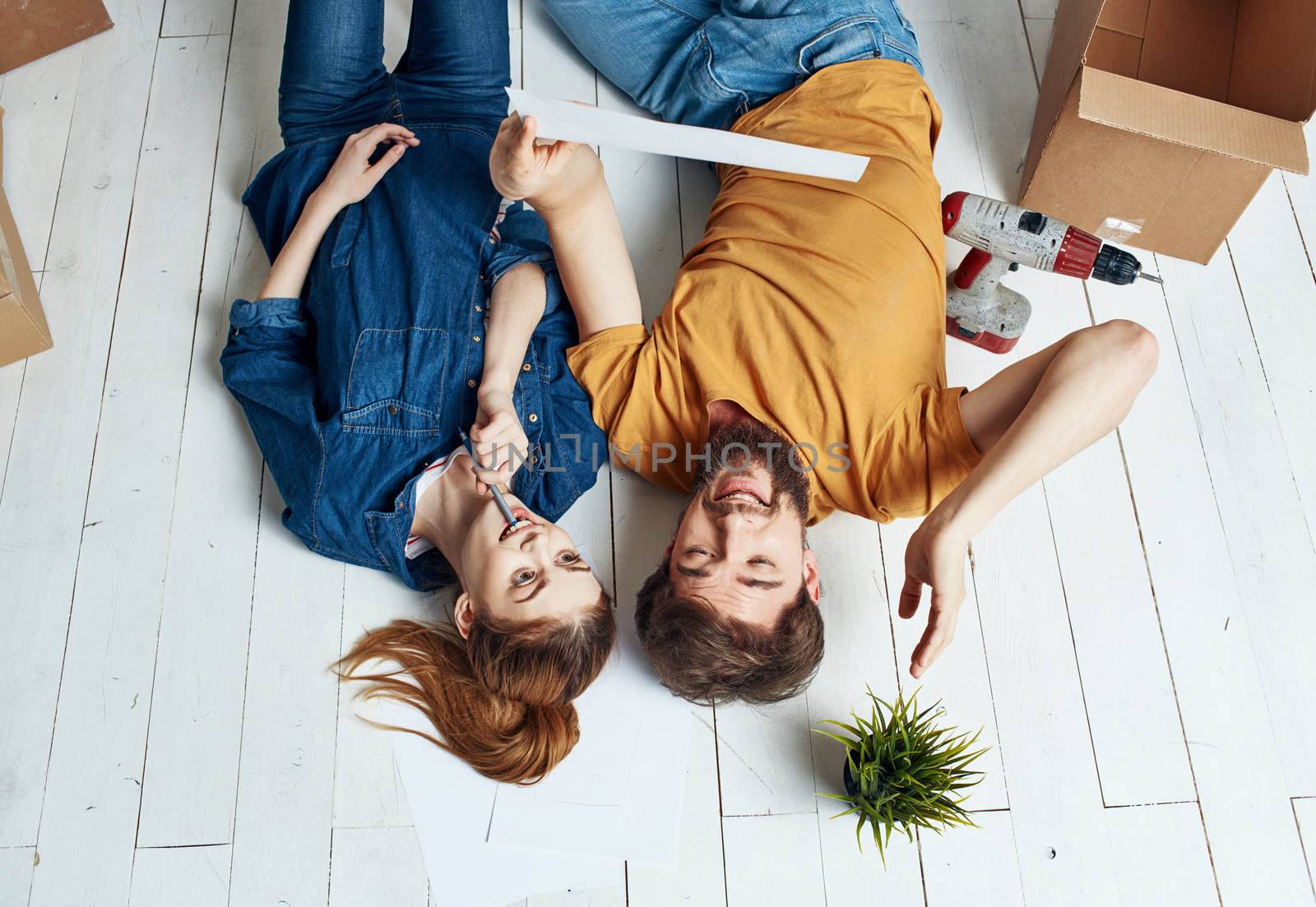 Man and woman with boxes on the floor a flower in a pot moving to repair work. High quality photo