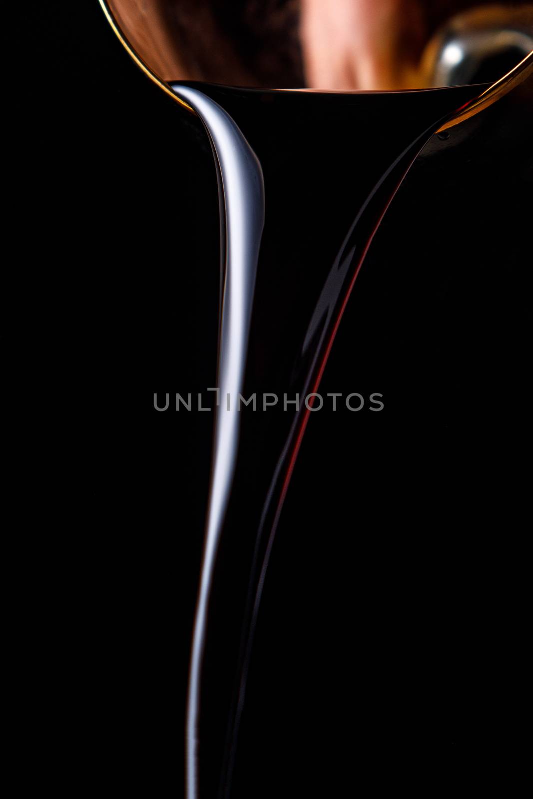 Black beer pouring on a black background. by 9parusnikov