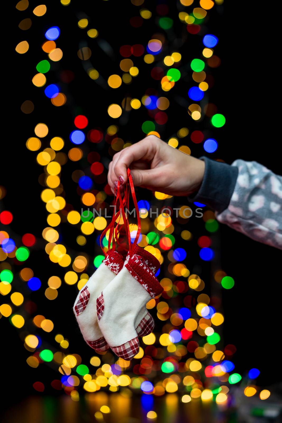 Woman's hands hold christmas decoration. Christmas and New Year holidays background, winter season with Christmas ornaments and blurred lights