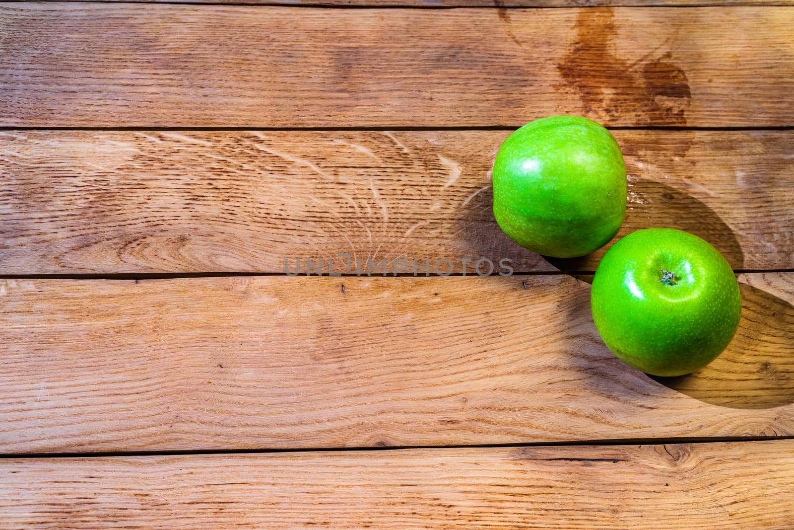 Detail on ripe green apples on wooden table.