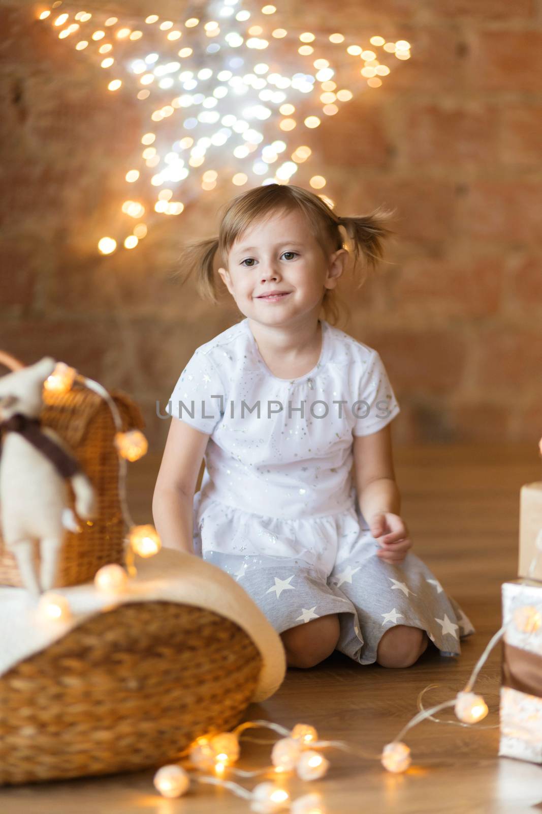 .Cute little girl sitting on the floor among the new year garlands by galinasharapova