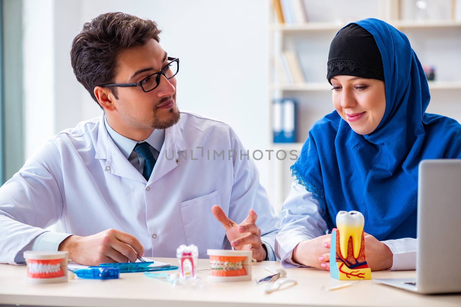 Dentist doctor and assistant working on new tooth implant by Elnur