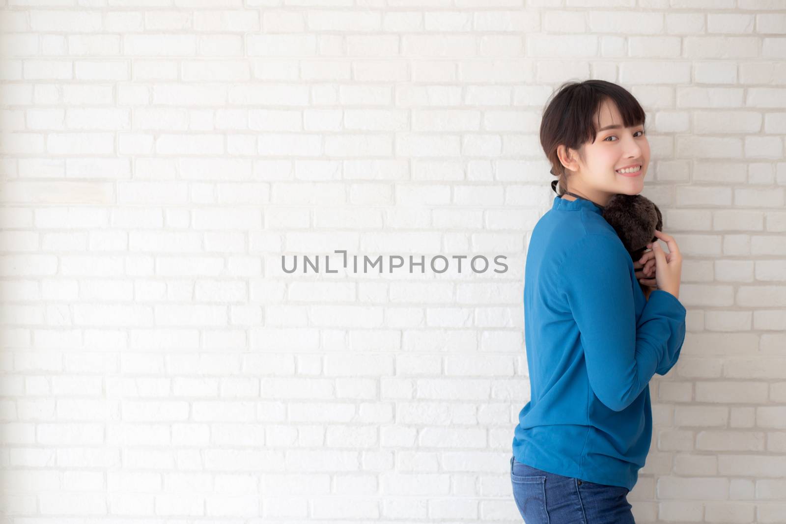 Portrait of beautiful young asian woman enjoy and happiness standing on gray cement texture grunge wall brick background, girl is a smiling and cheerful on concrete.