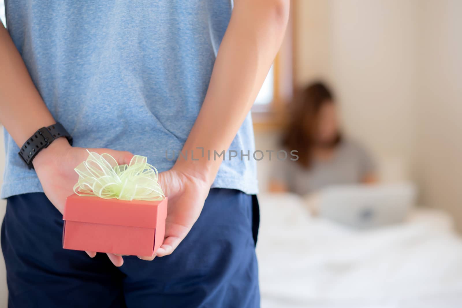 Beautiful young asian couple in love surprise gift box in bedroo by nnudoo