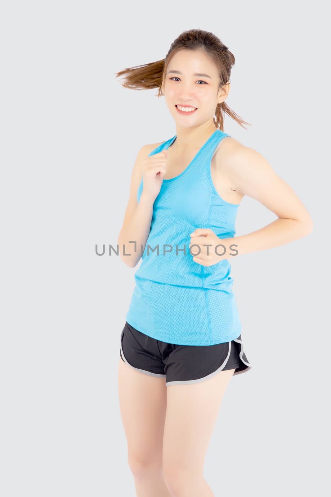 Beautiful young asian woman happy and smiling jogging isolated o by nnudoo