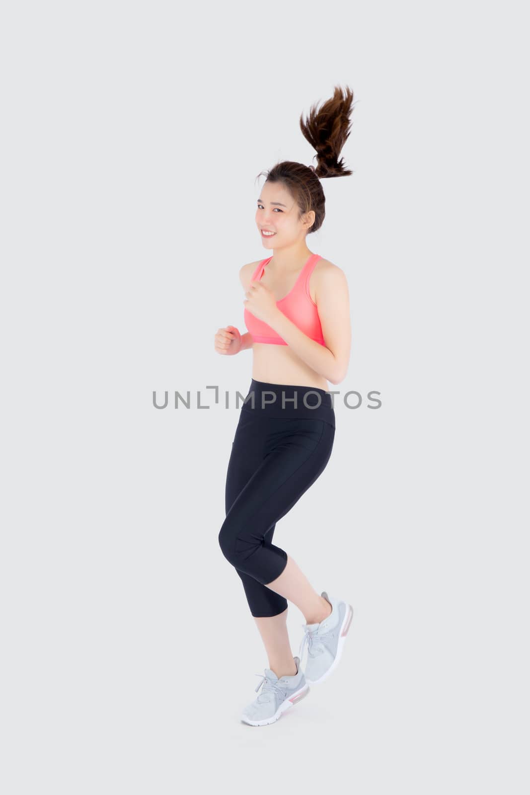 Beautiful young asian woman happy and smiling jogging isolated o by nnudoo