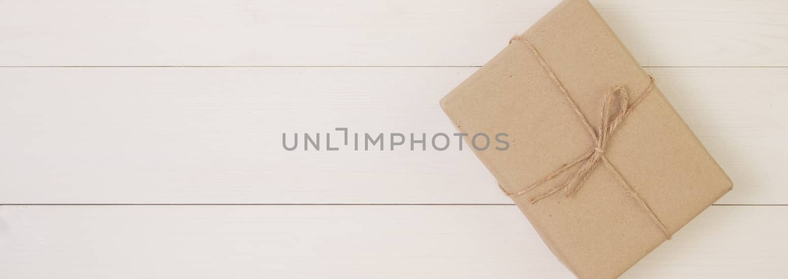 Gift box on wooden background with romantic, presents for mother day or valentine day with pastel tone, package with congratulation, nature for decoration on desk, holiday concept, banner website.