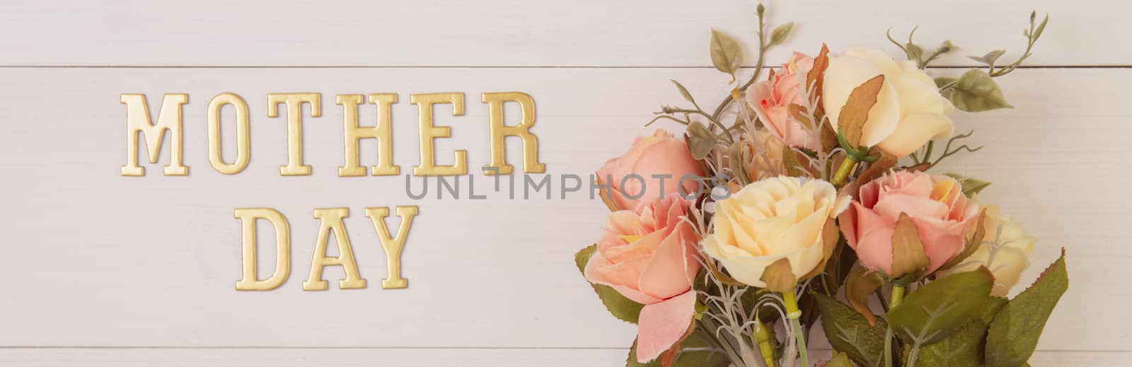 Beautiful flower and text mother day on wooden background with romantic, spring or summer nature for decoration, bouquet floral and word or message for gift on desk, holiday concept, banner website.