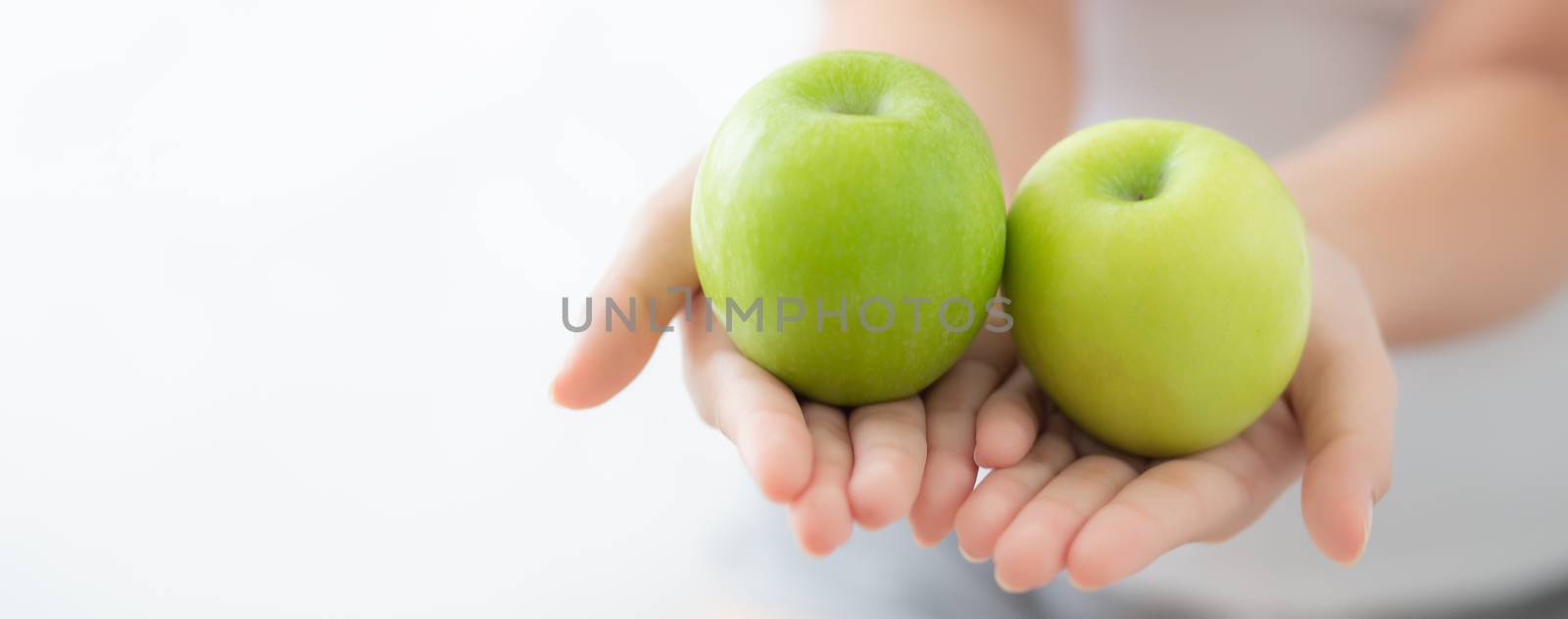 Closeup of beautiful woman holding and eating green apple fruit  by nnudoo