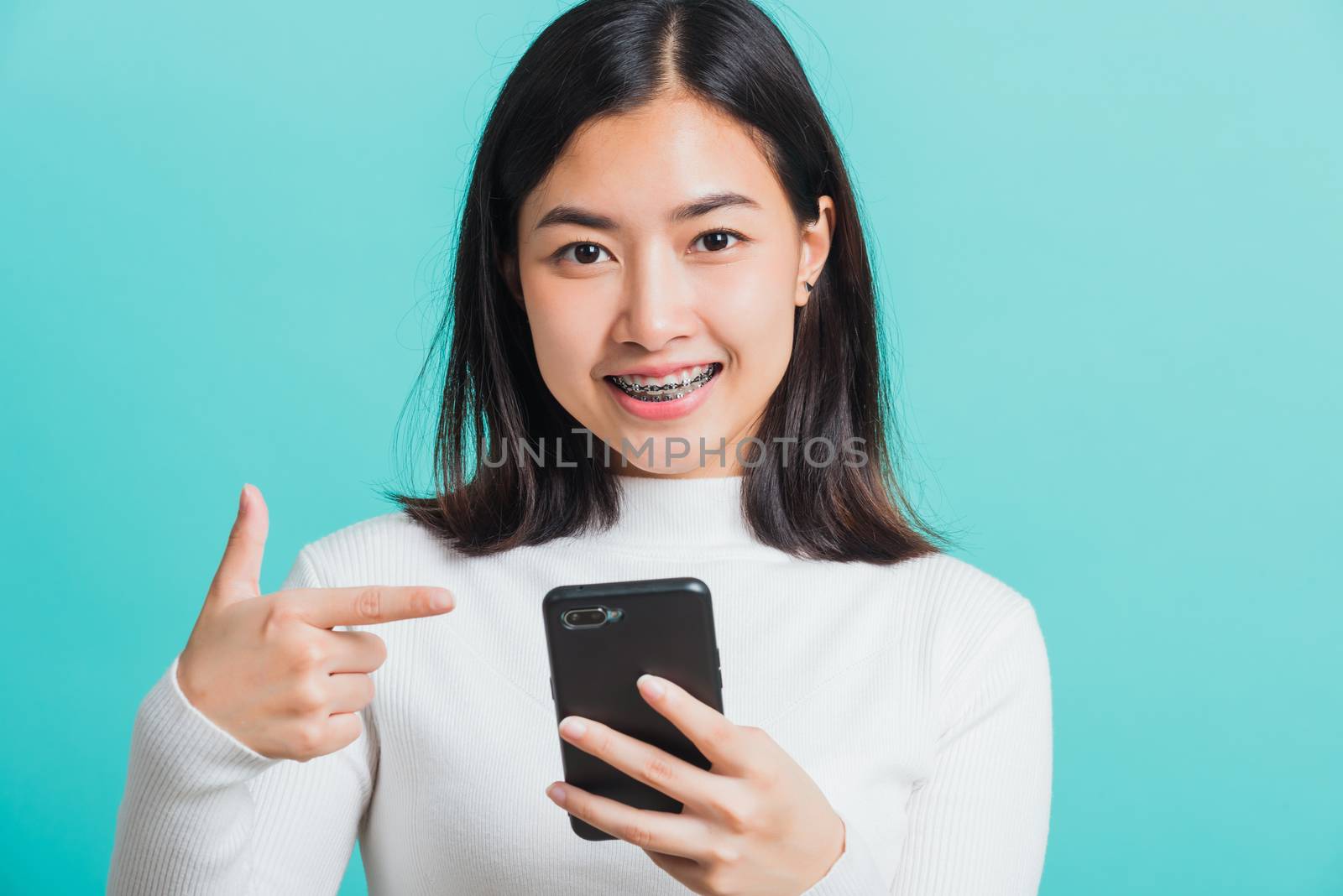 woman smile she pointing finger to a smartphone by Sorapop
