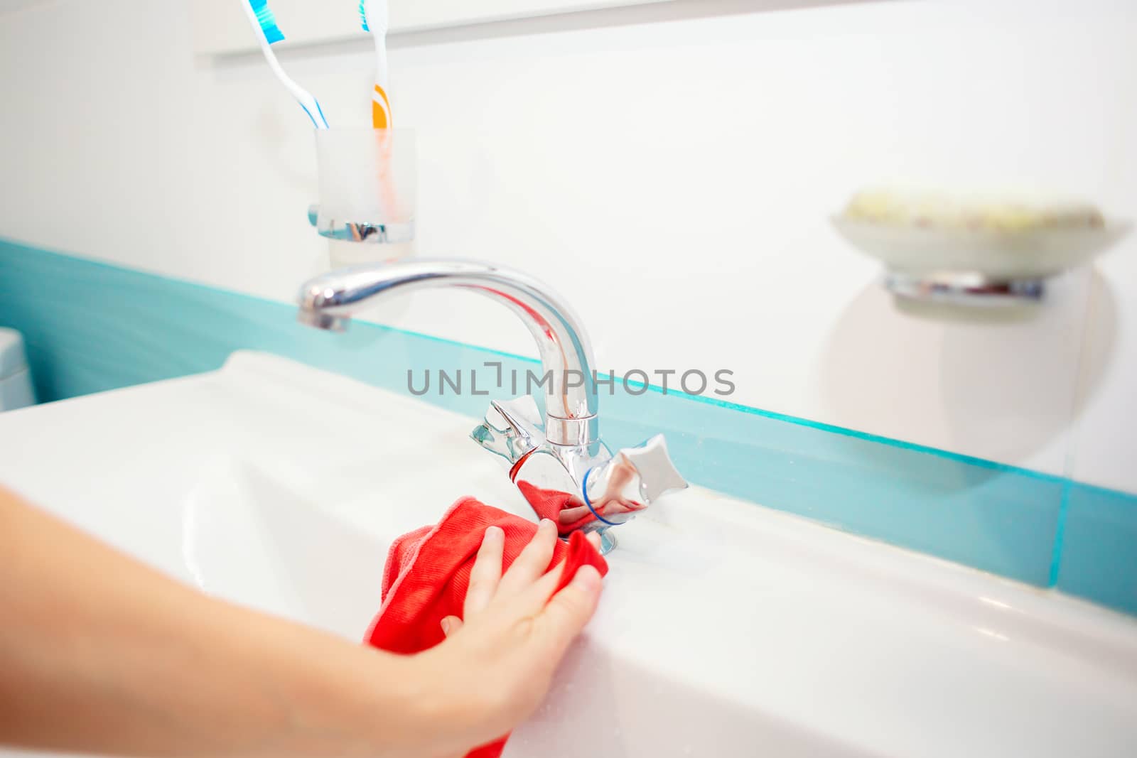 Washing the sink and faucet in the bathroom. Disinfection at home. Tidying up the house. Spring-cleaning. Toilet cleaning. Cleaning the sink with a rag