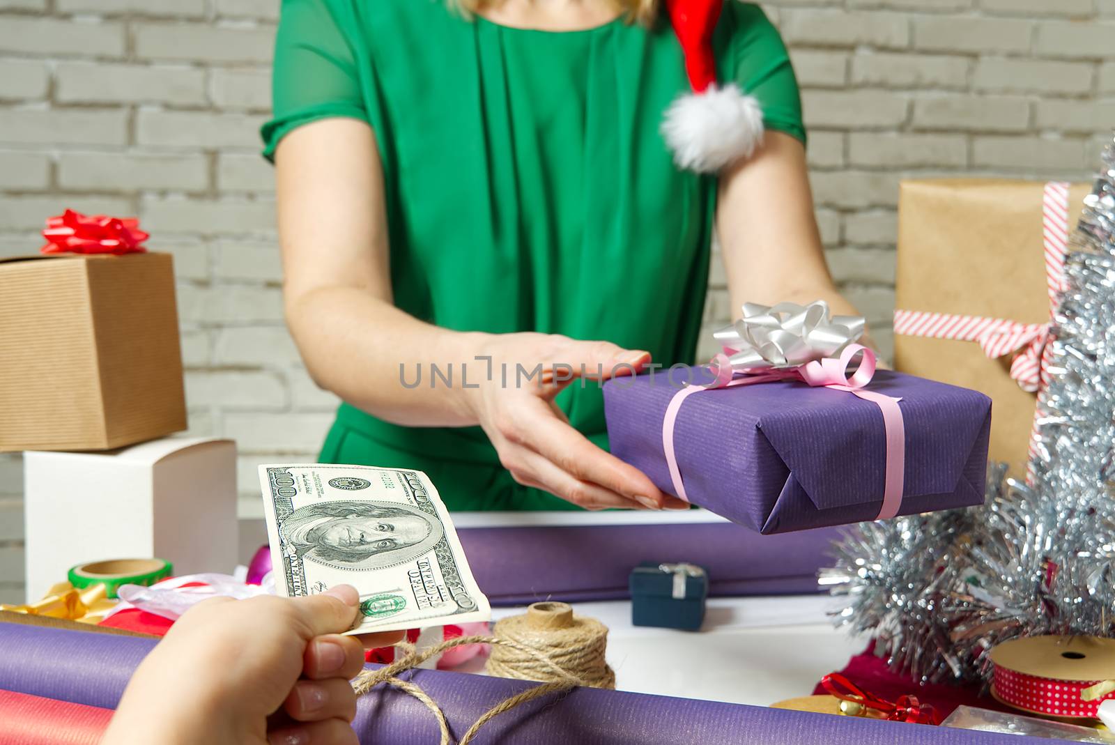 Paying for Gift Wrap at wrapping and packing service table with USA dollars banknotes.