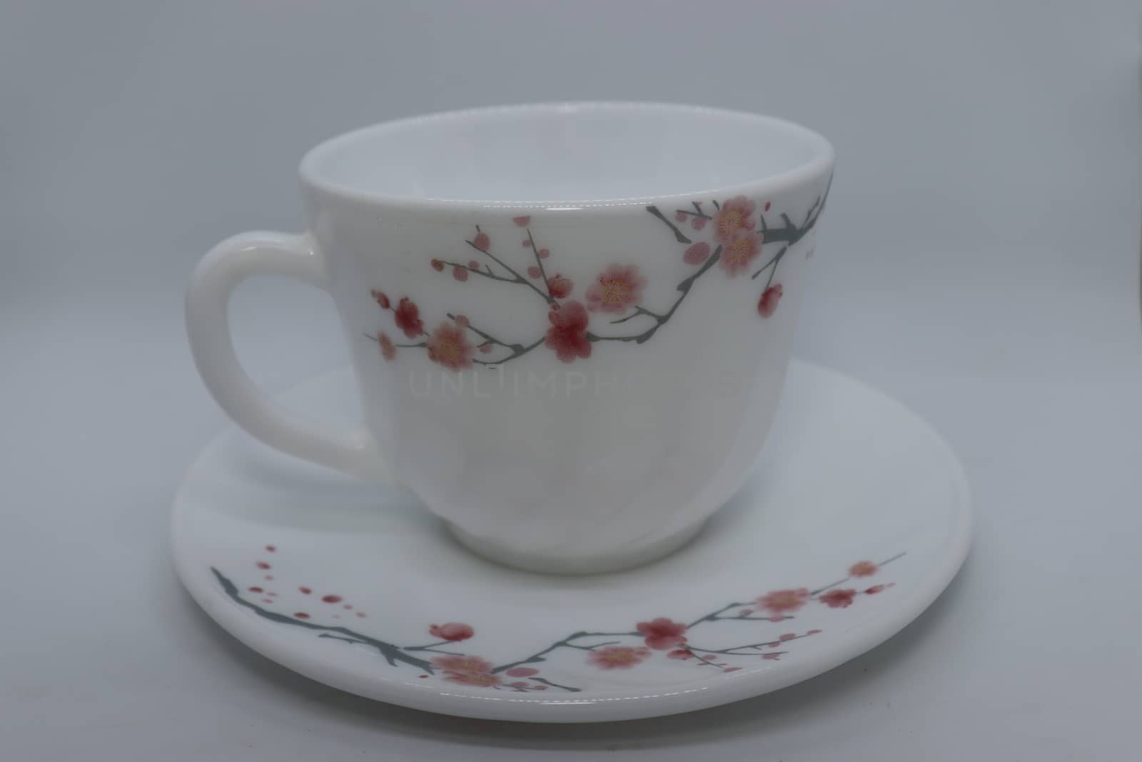 ceramic cup and plate closeup on white background