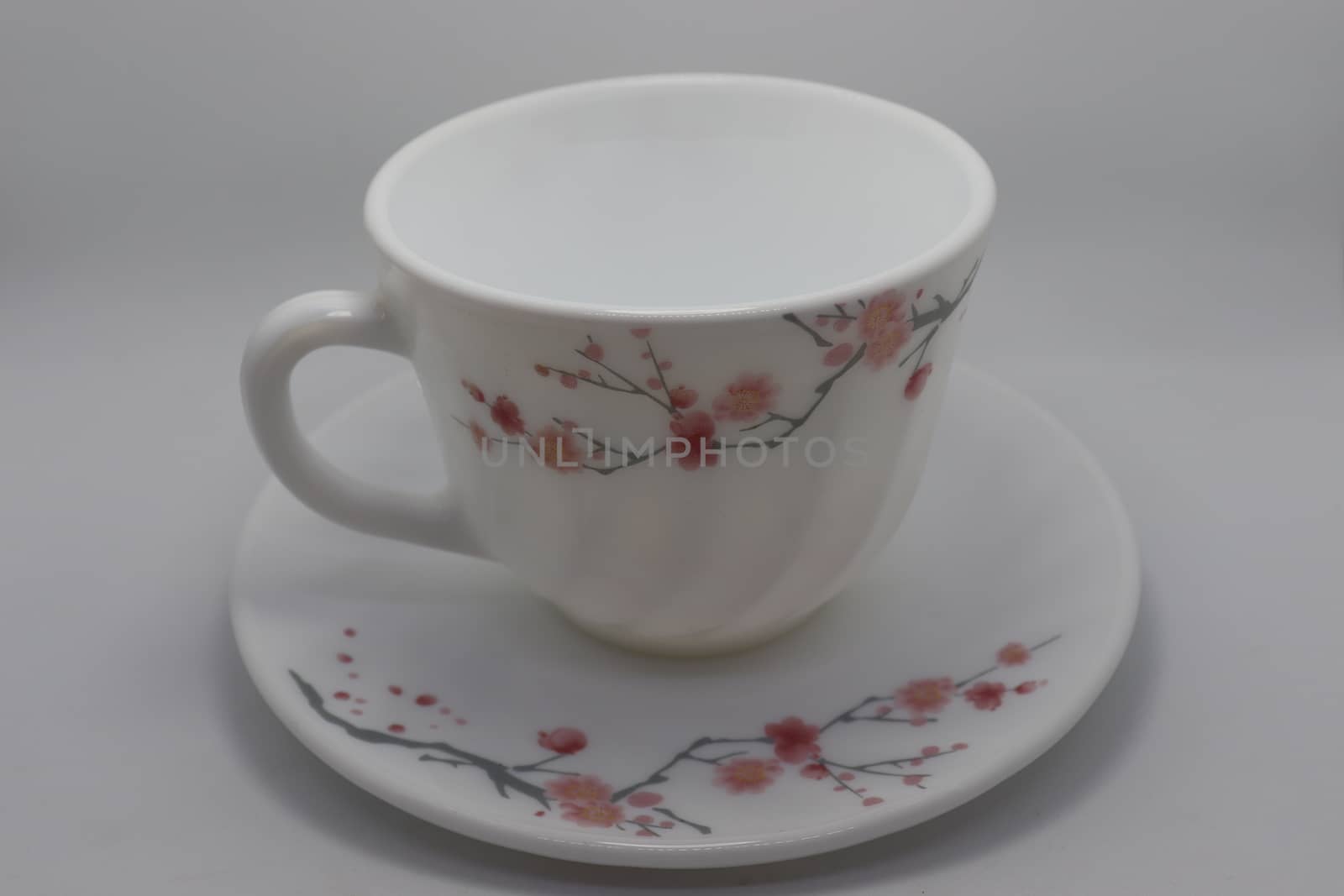 ceramic cup and plate closeup on white background