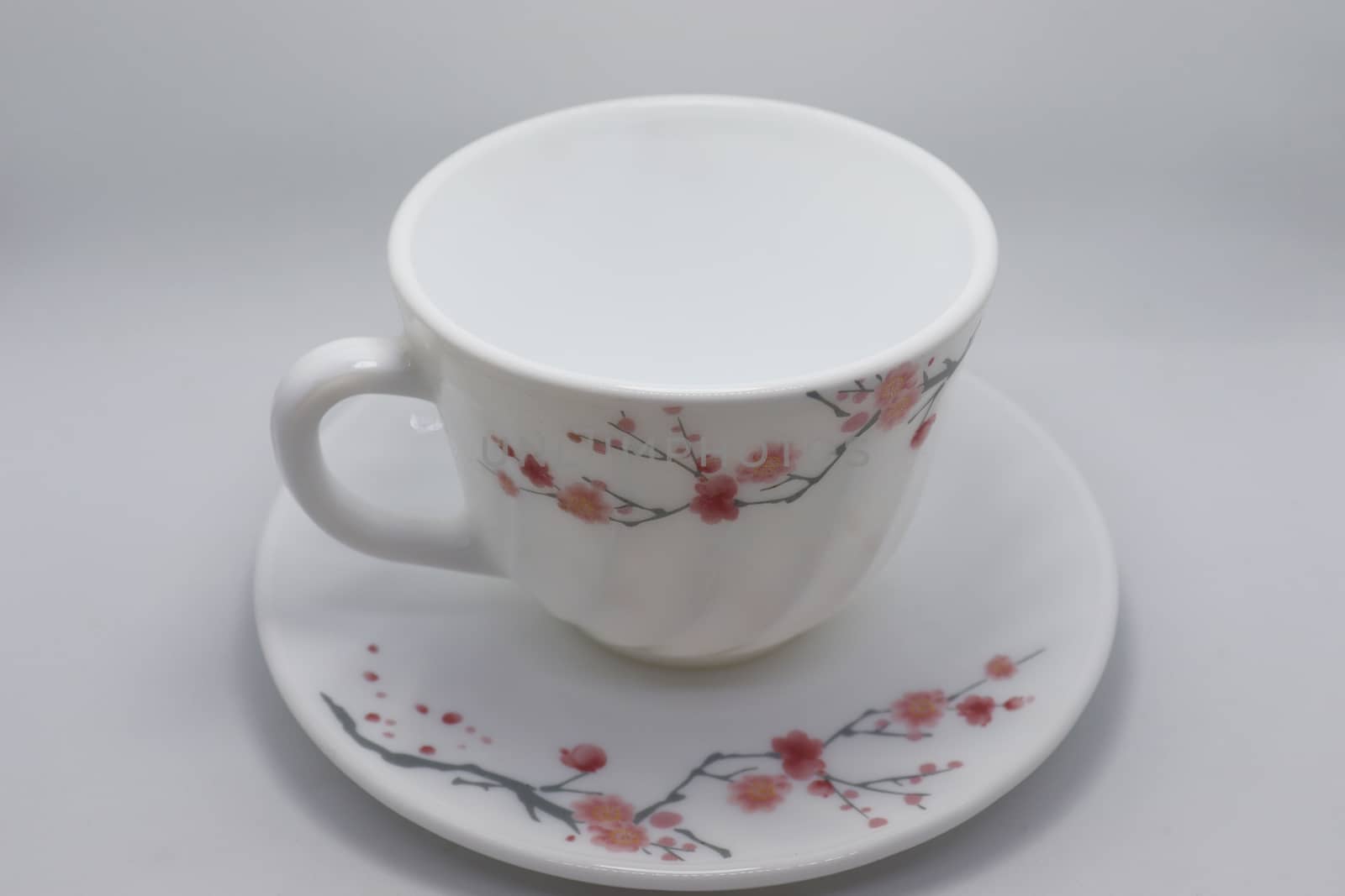 ceramic cup and plate closeup on white background