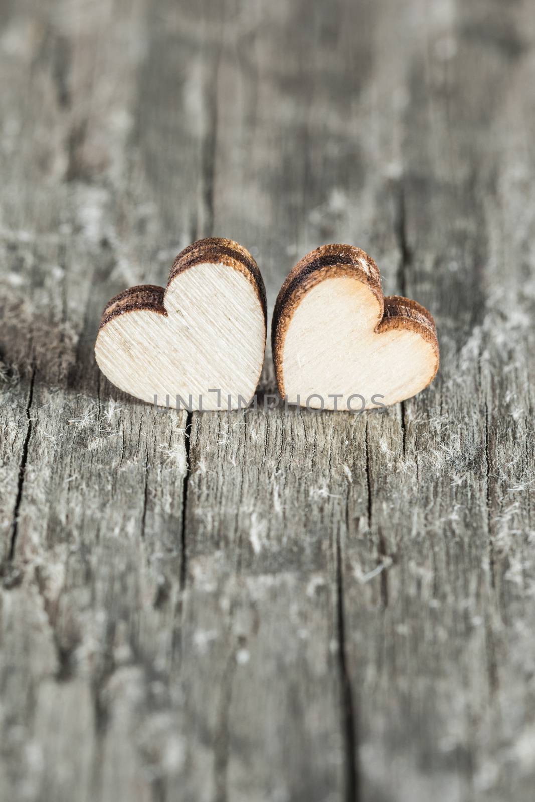 Two handmade wooden carved hearts on light wood background couple relationship Valentine day concept
