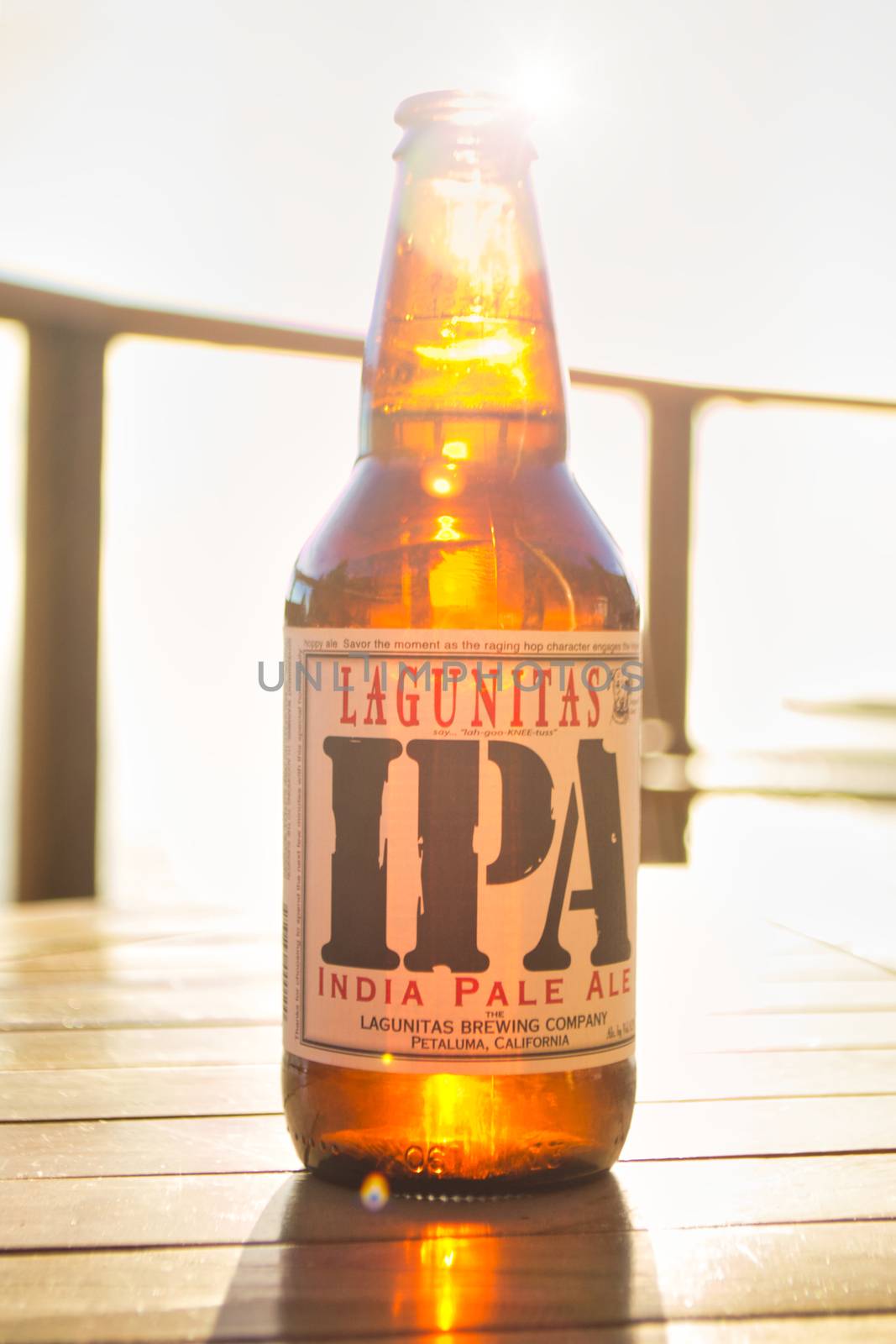 Big Sur, United States, November 2013: Illustrative Editorial: Lagunitas IPA India Pale Ale beer bottle against strong sunlight. Wooden table.