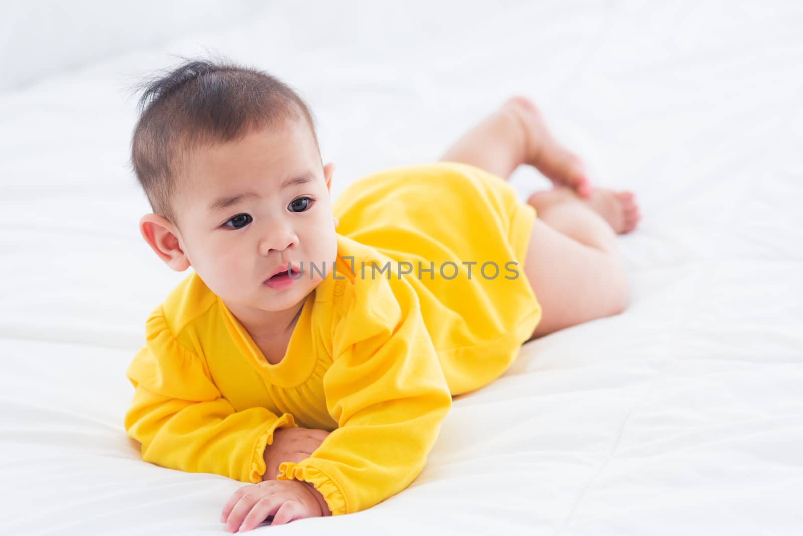 newborn little baby prone on the bed at home by Sorapop