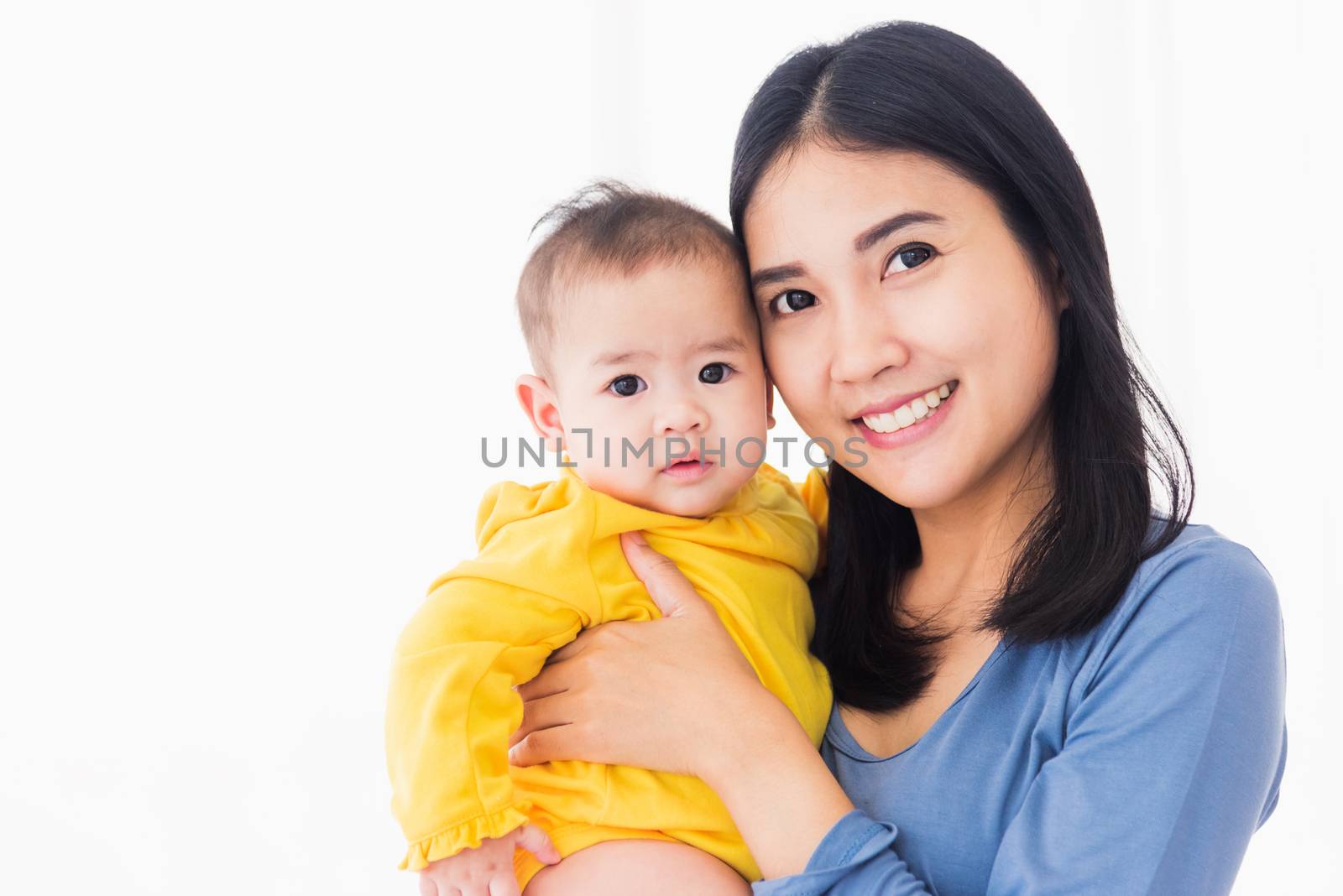 Portrait of beautiful young Asian mother holding his newborn little baby in her arms at home, Parent mom hugging her newborn child, happy family