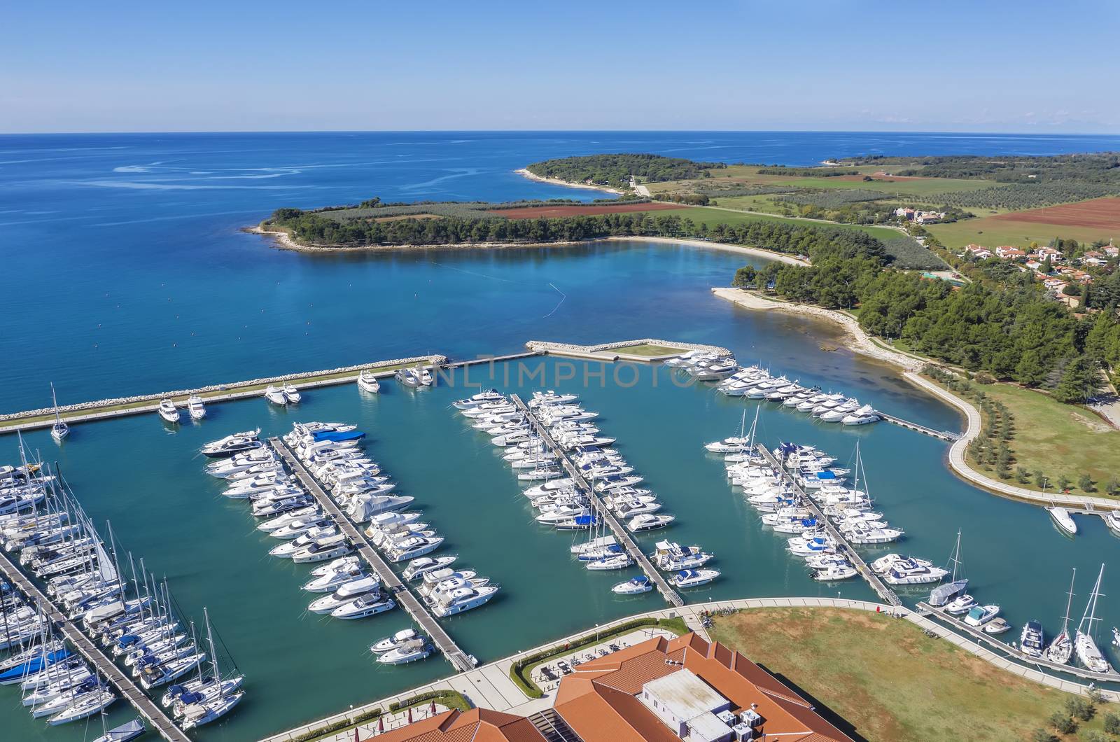 an aerial shot of coastal city Novigrad with boats and yachts in marina, Istria, Croatia