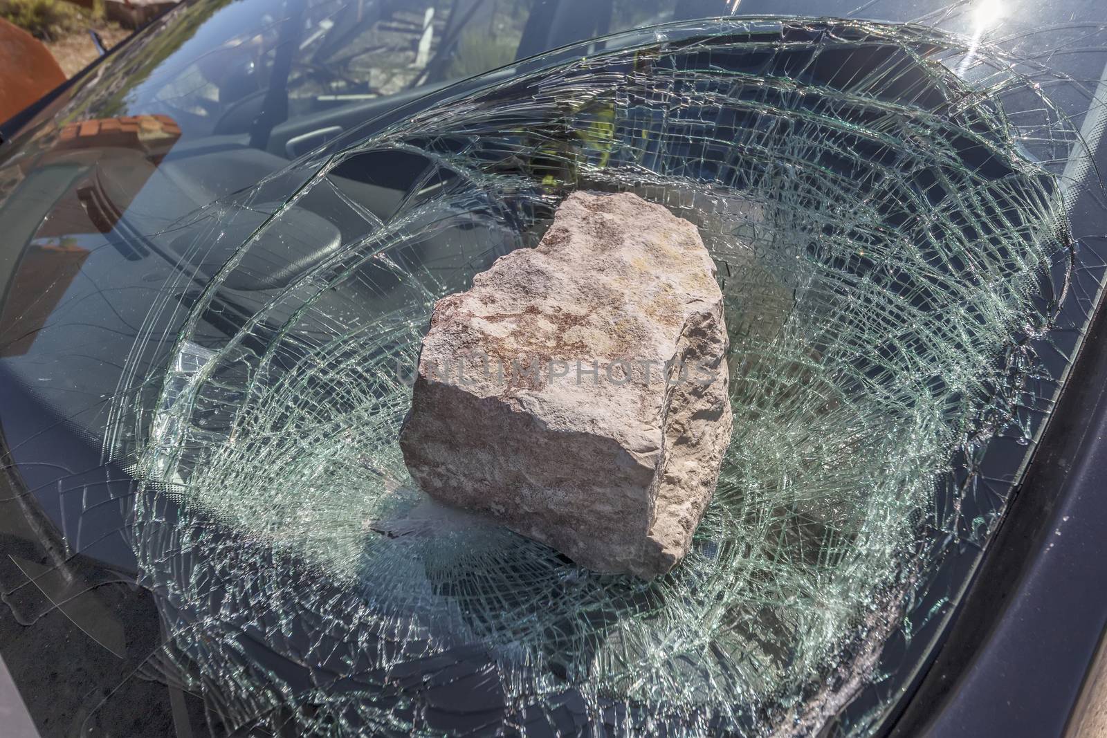 broken car windshield with a huge stone
