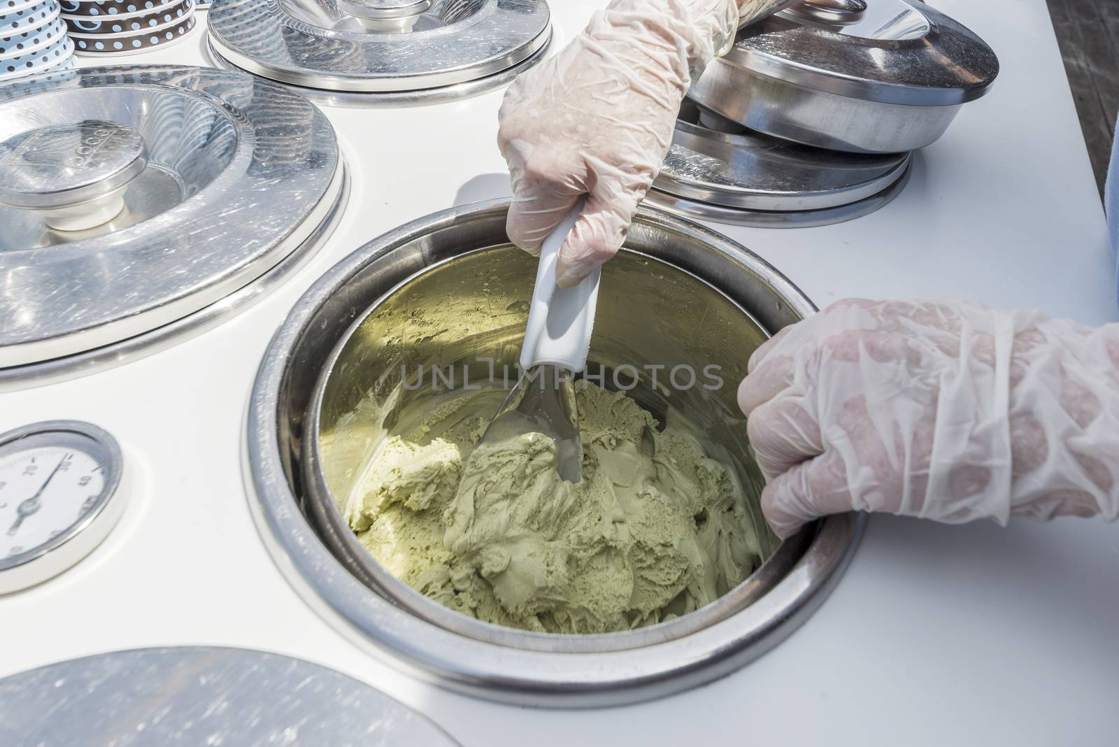 chef mixing pistachio icecream in inox bowl
