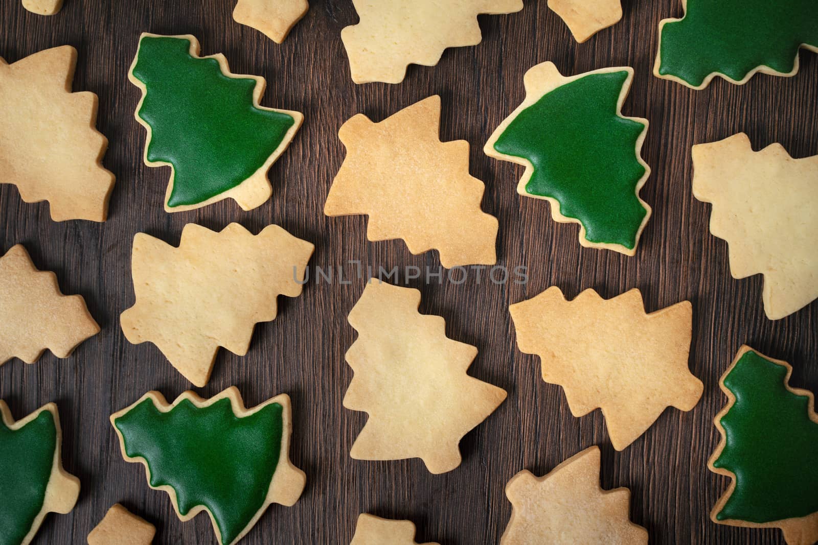 Top view of decorated green plain flavor gingerbread Christmas tree cookie on wooden table background with copy space, concept of holiday celebration.
