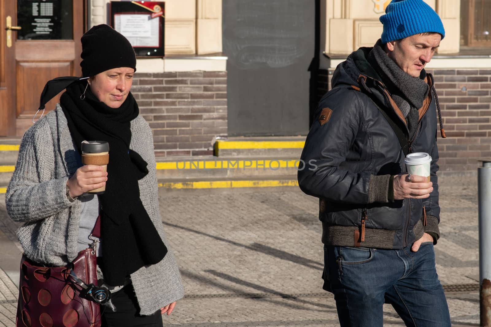 People on a sunny winter day during coronavirus. They are walking or doing some sports or having a time relax at Hradcanska metro stop in Prague. by gonzalobell