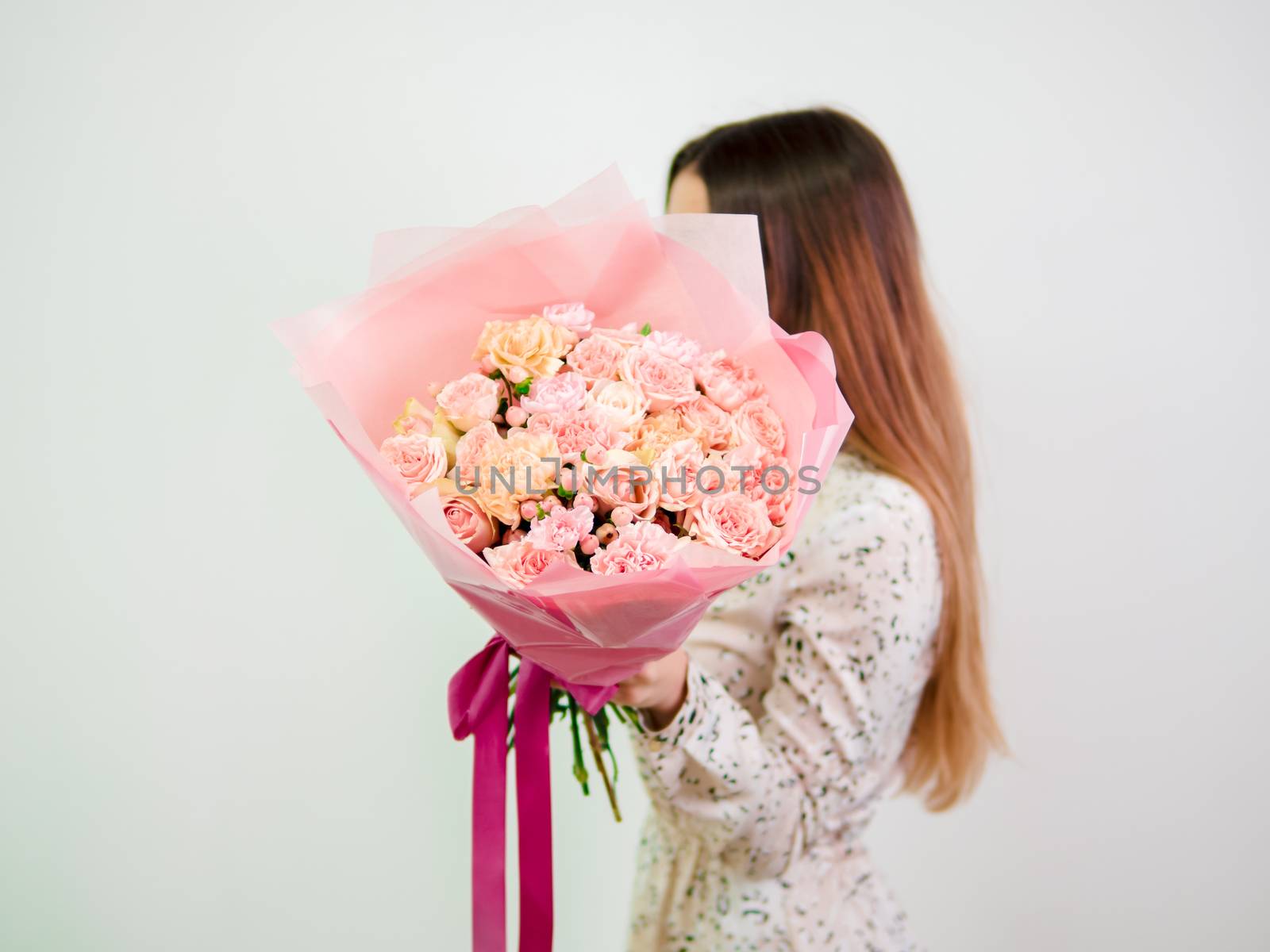 Beautiful bouquet with different pink flowers in woman hands. Nice subtle delicate pink bouquet with roses, dianthus, hypericum, clove. Shallow DOF. Copy space for text.