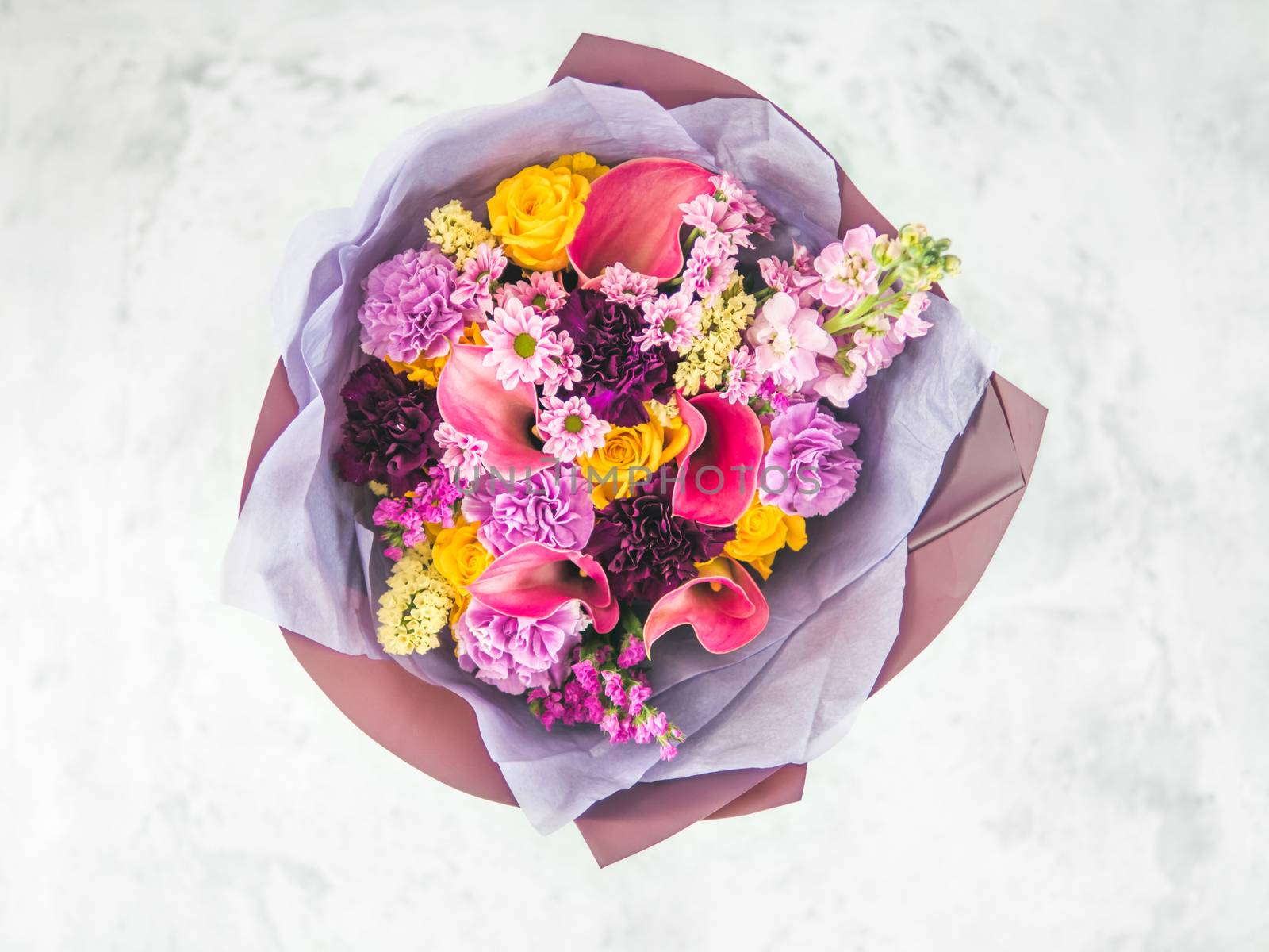 Lilac bouquet with arum lily or calla, roses, dianthus, chrysanthemum, limonium, matthiola. Focus on calla. Shallow DOF, copy space