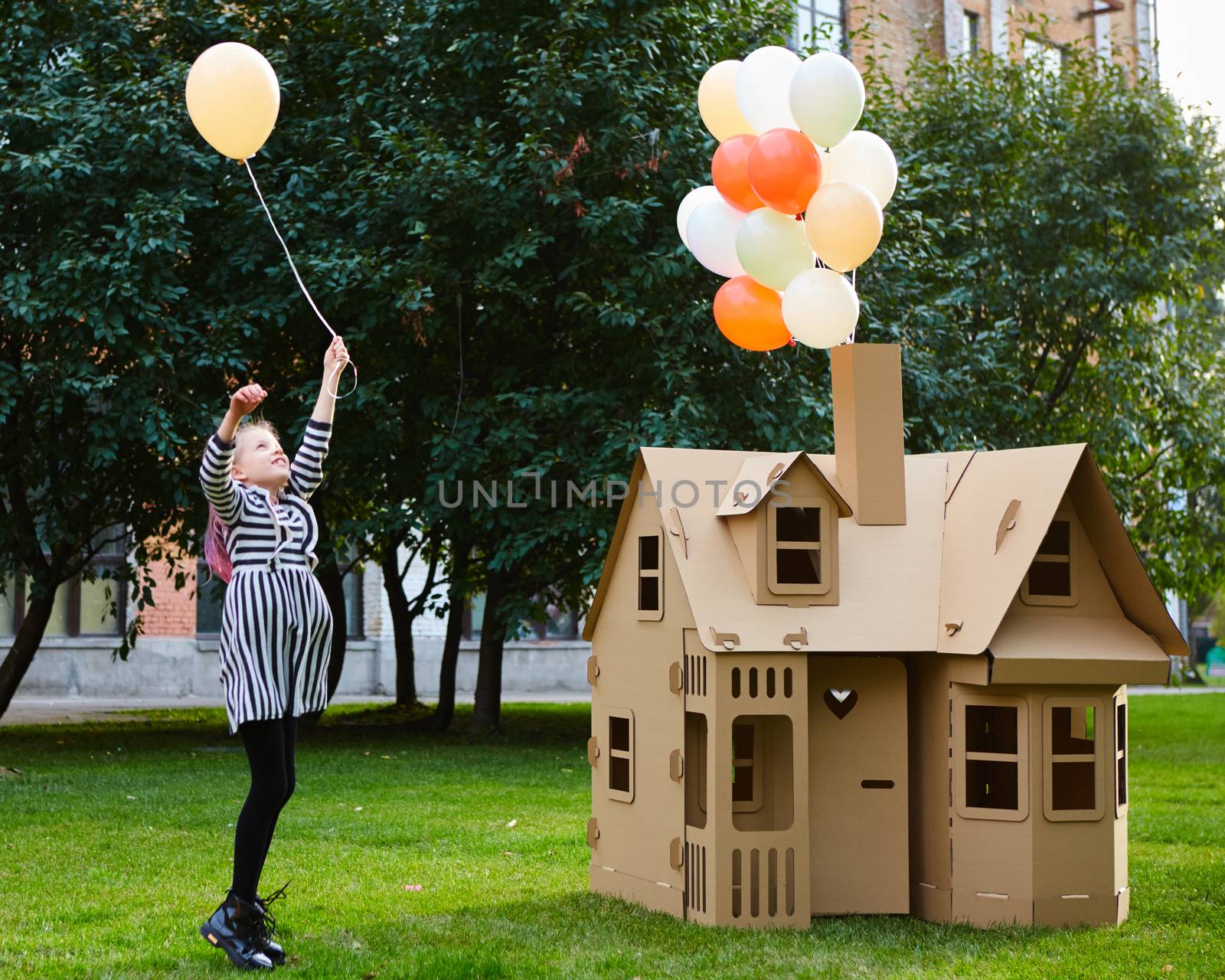 Child playing in a cardboard playhouse. Eco concept.