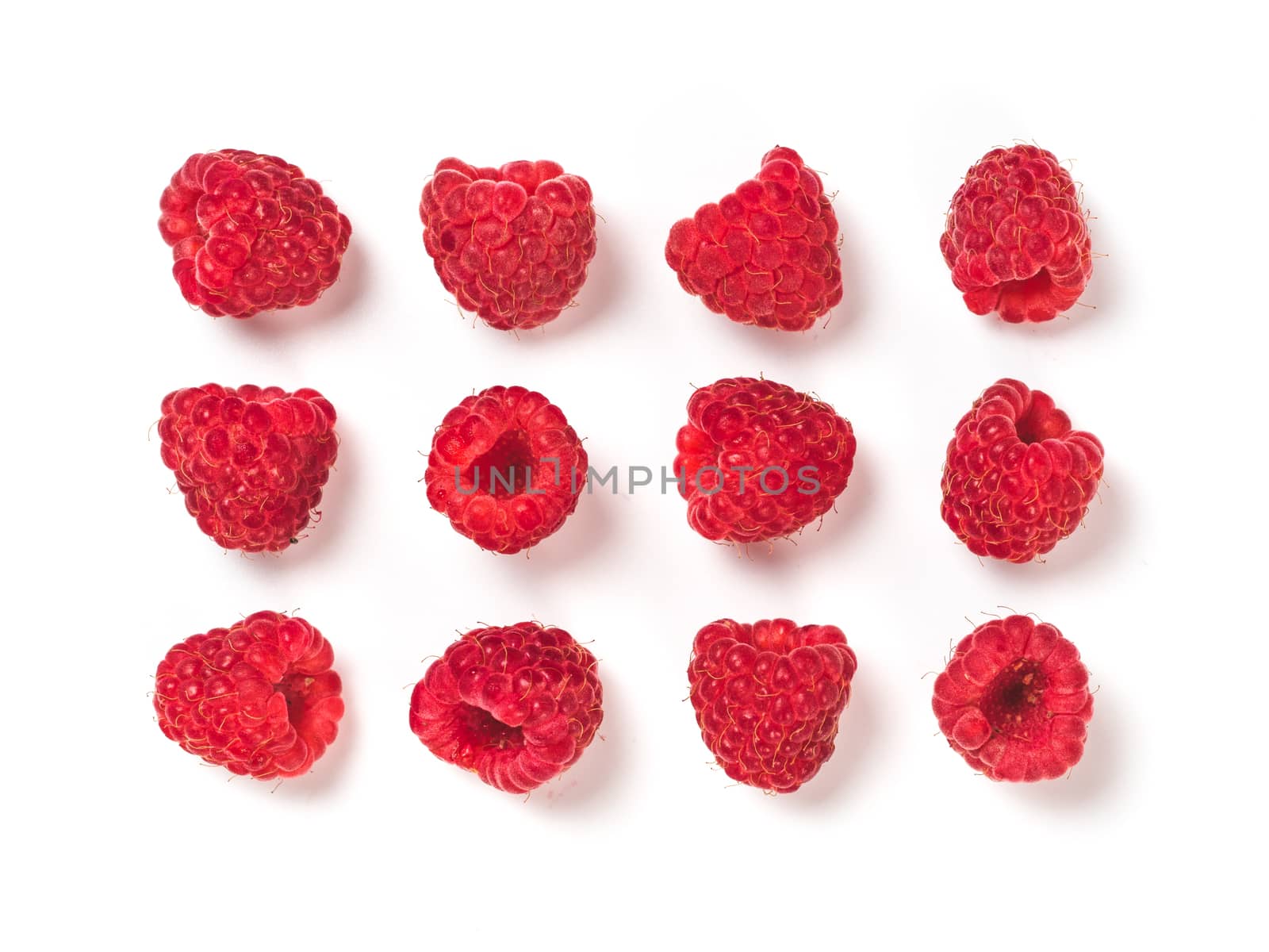 View from above of ripe red raspberry on white background. Organic raspberries creative layout pattern, isolated on white with clipping path. Top view or flat lay. Vegan food concept