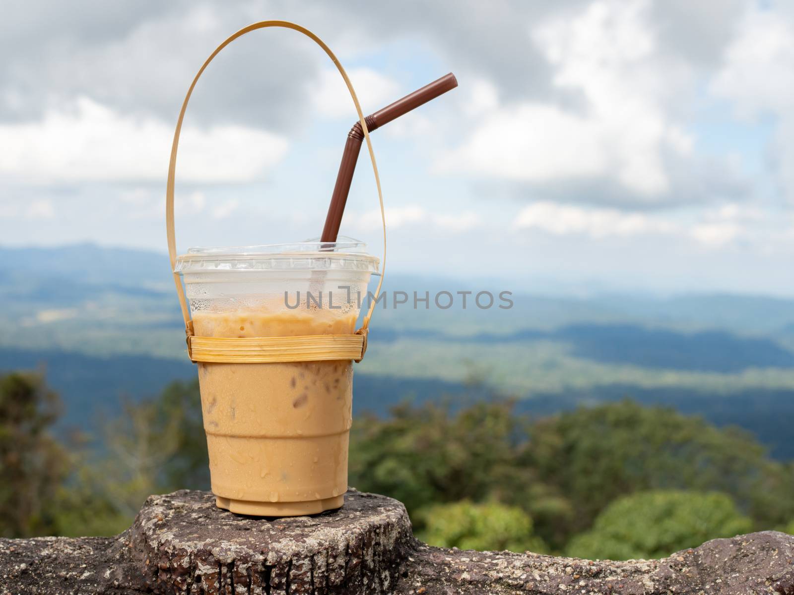 A glass of Thai tea on a mountain background in Khao Yai National Park