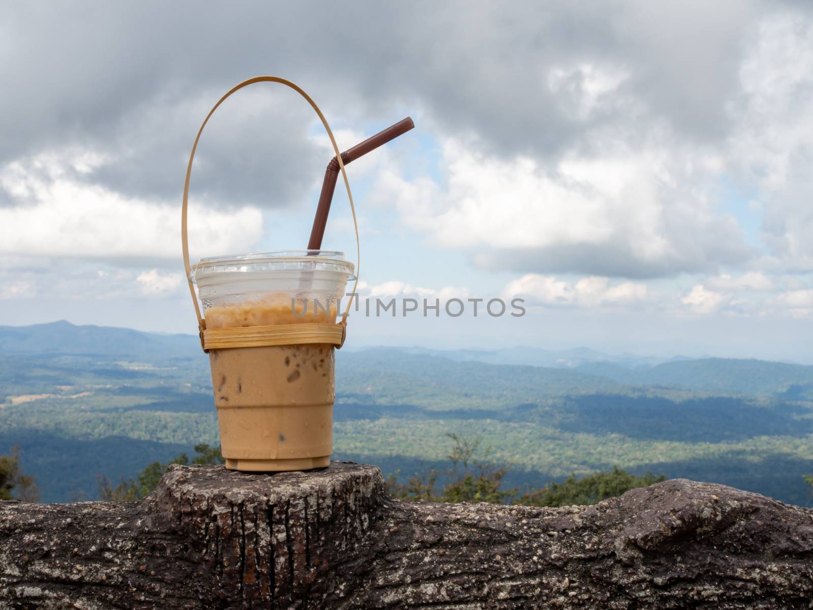 A glass of Thai tea on a mountain background in Khao Yai Nationa by Unimages2527