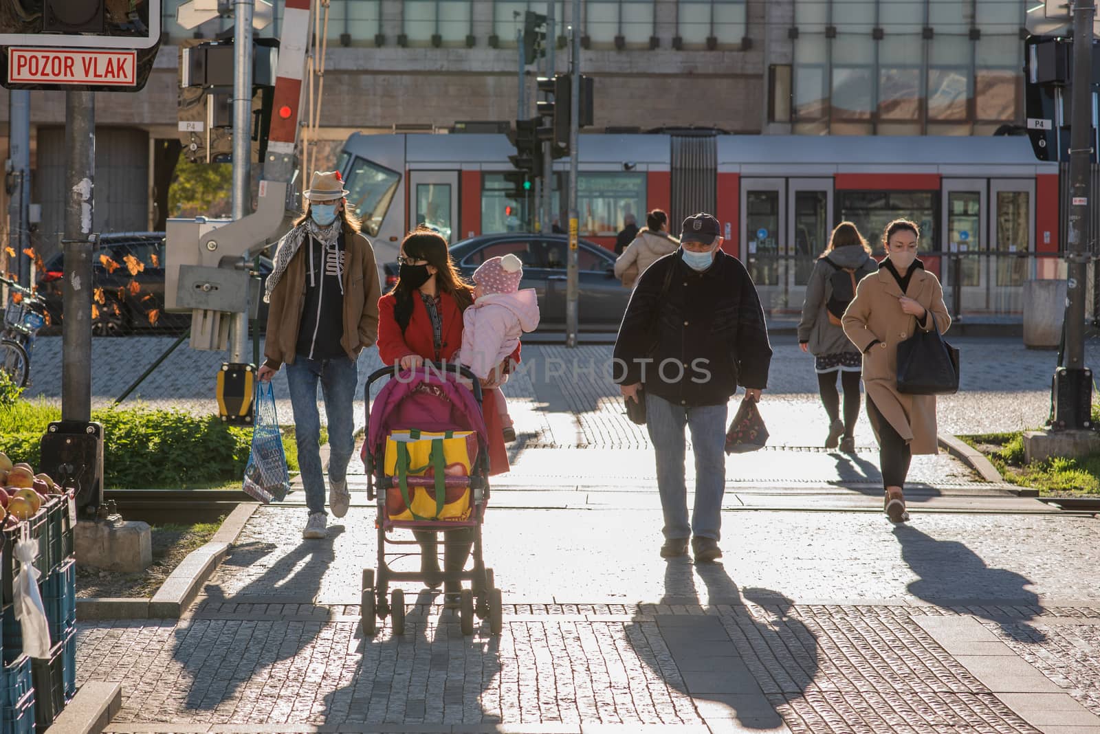 People on a sunny winter day during coronavirus. They are walking or doing some sports or having a time relax at Hradcanska metro stop in Prague. by gonzalobell