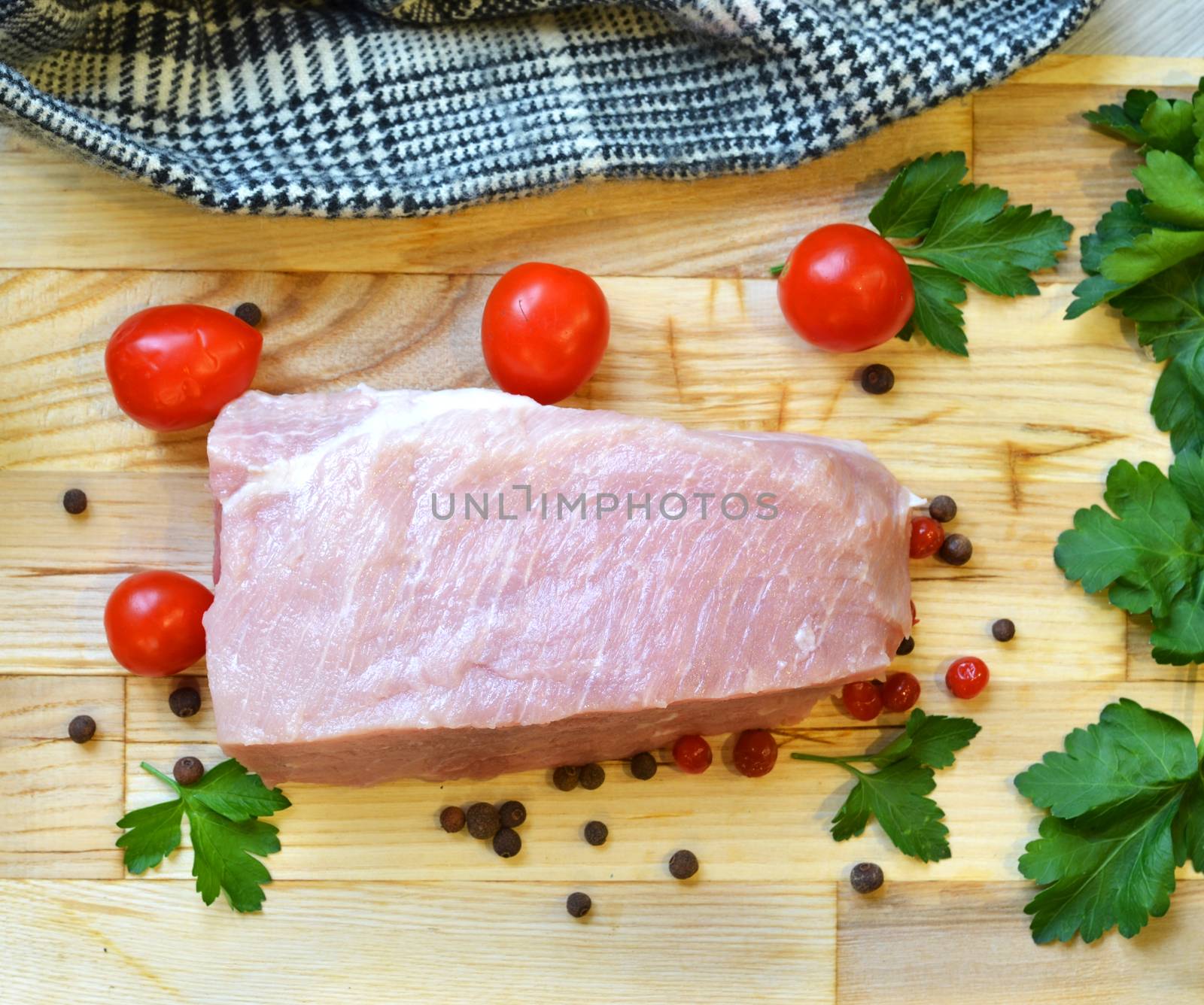 Raw pork meat on cutting board and vegetables and greens by lucia_fox