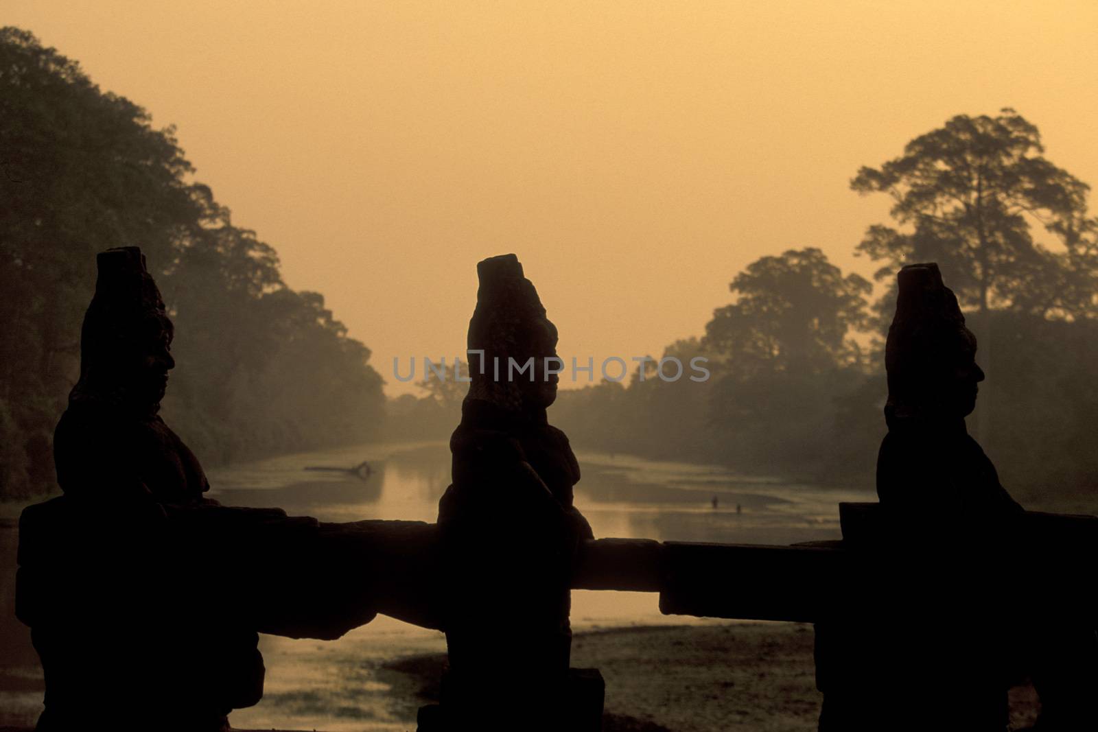 stone face at the Bridge of the south gate to the Angkor Tom city in the Temple City of Angkor near the City of Siem Reap in the west of Cambodia.  Cambodia, Siem Reap, February, 2001