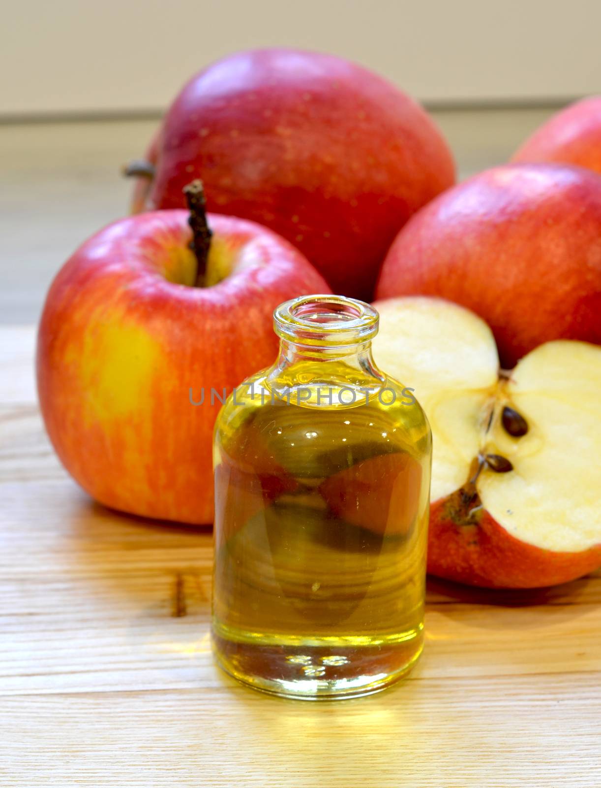 Apple cider vinegar in glass bottle and fresh apples on wooden background by lucia_fox