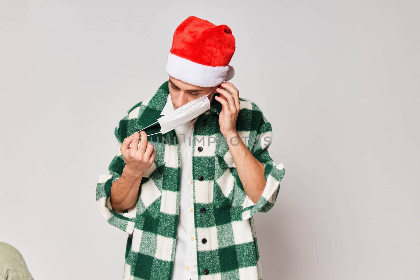 man in green plaid shirt santa hat medical mask gray background by SHOTPRIME