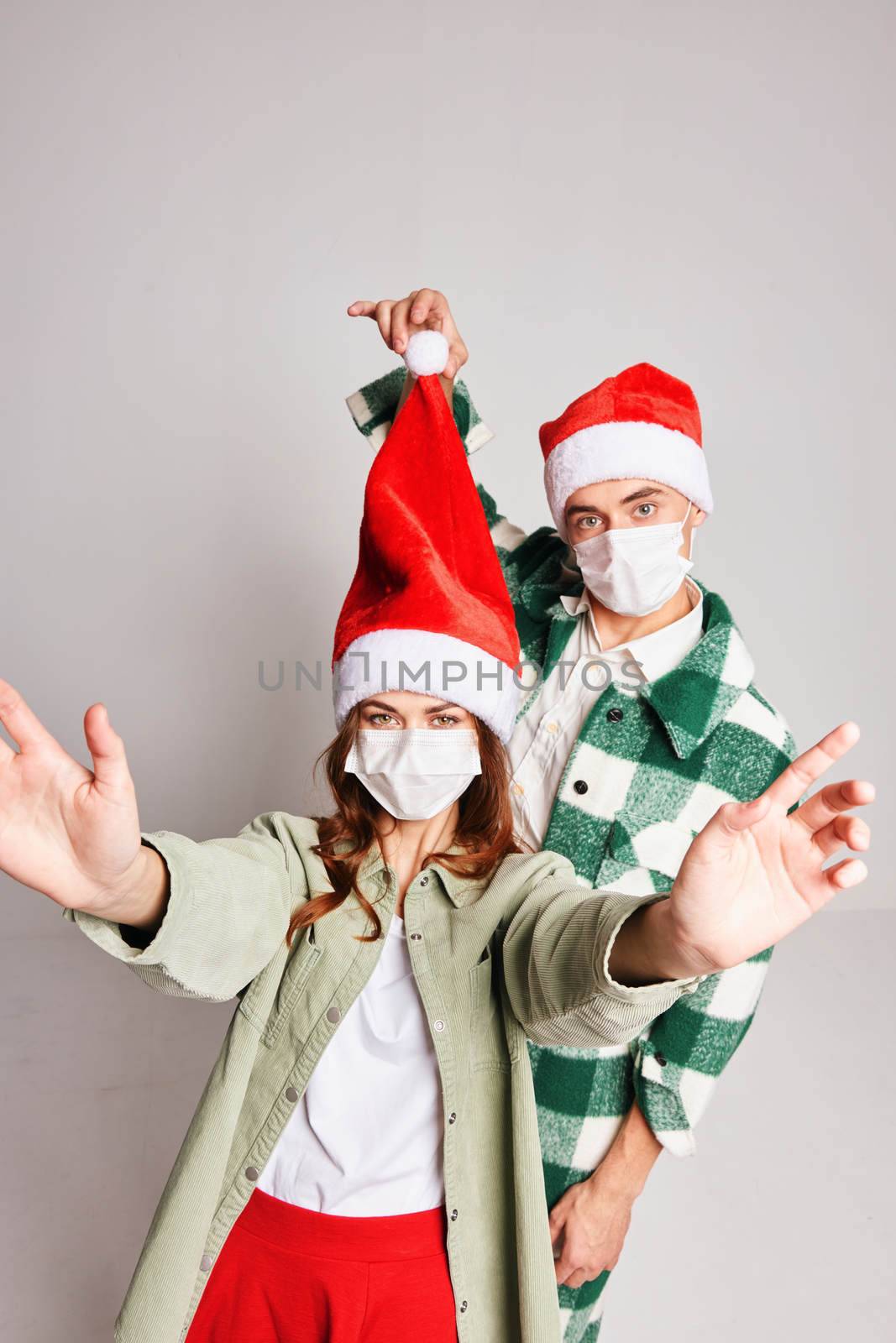 Young couple together New Years medical masks Merry Christmas fun by SHOTPRIME