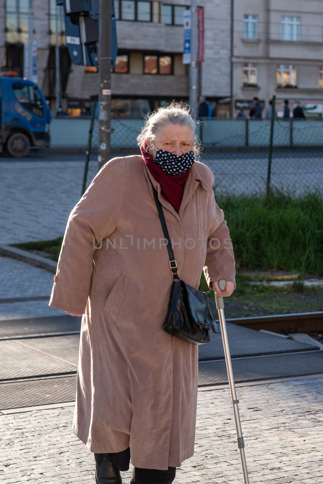 11-22-2020. Prague, Czech Republic. People during quarantine period due to coronavirus (COVID-19) at Hradcanska metro stop in Prague 6. Old woman walking.