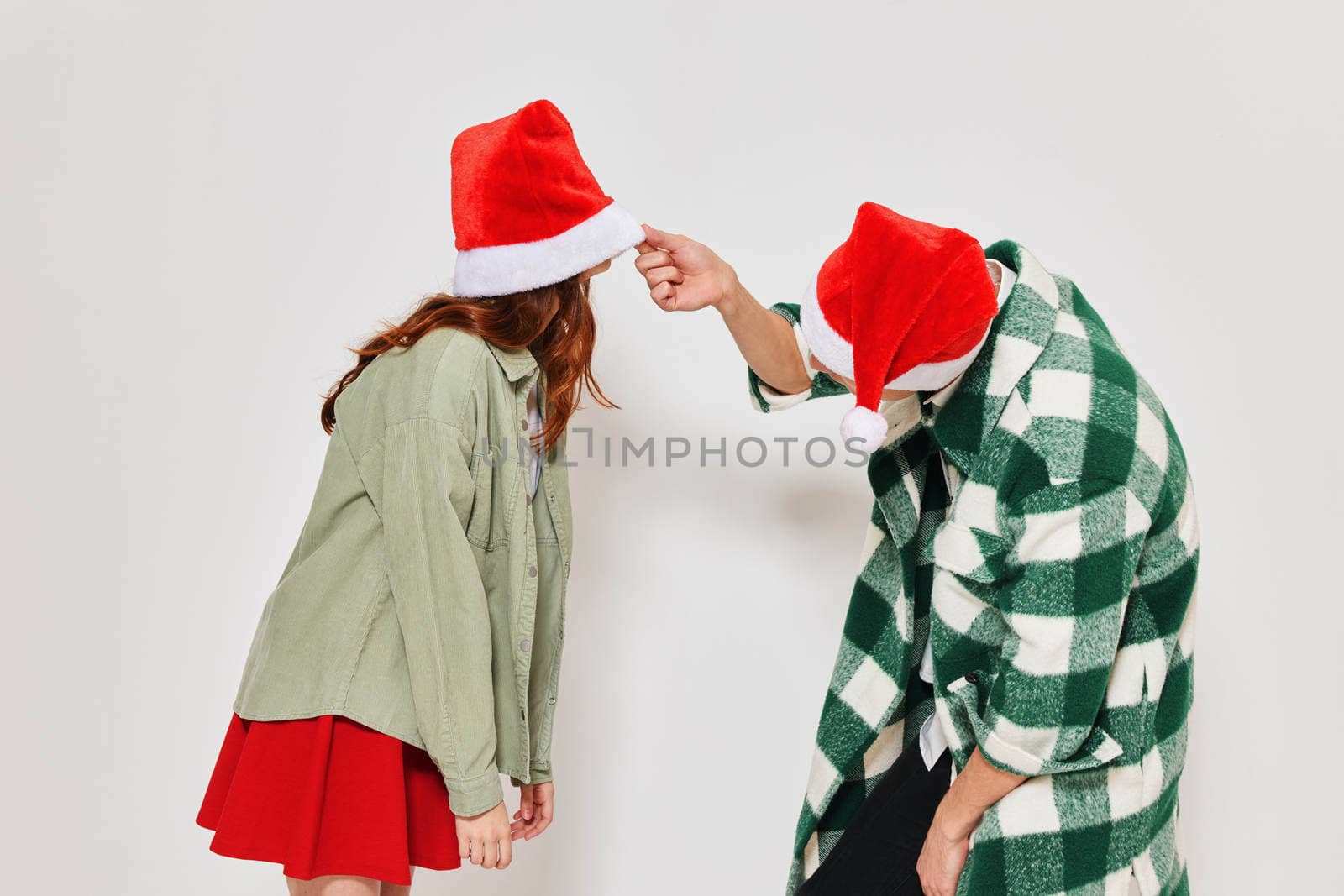 Young couple in Christmas hats holiday fashion studio friendship fun. High quality photo