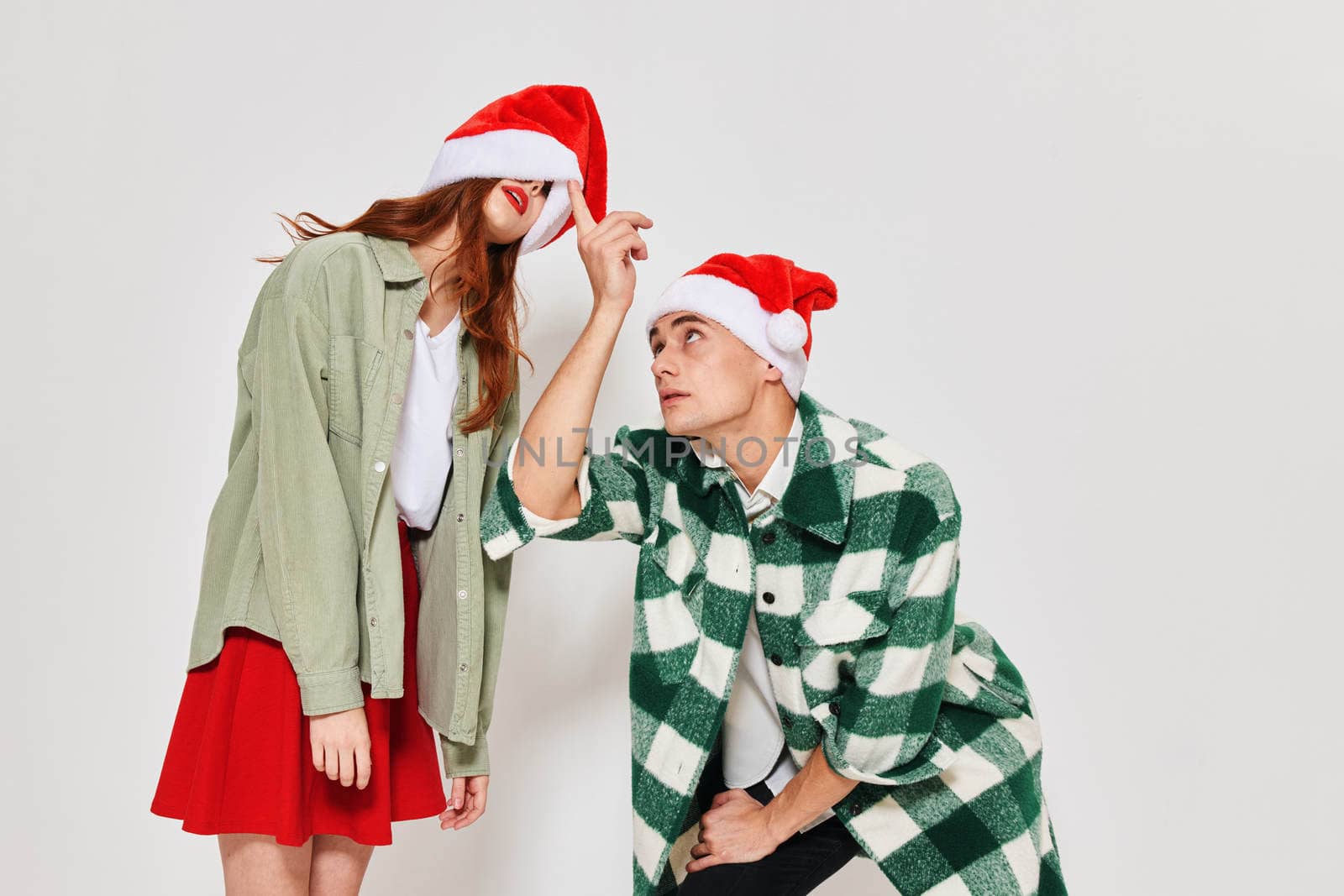 young couple in santa hats santa fun friendship together christmas by SHOTPRIME