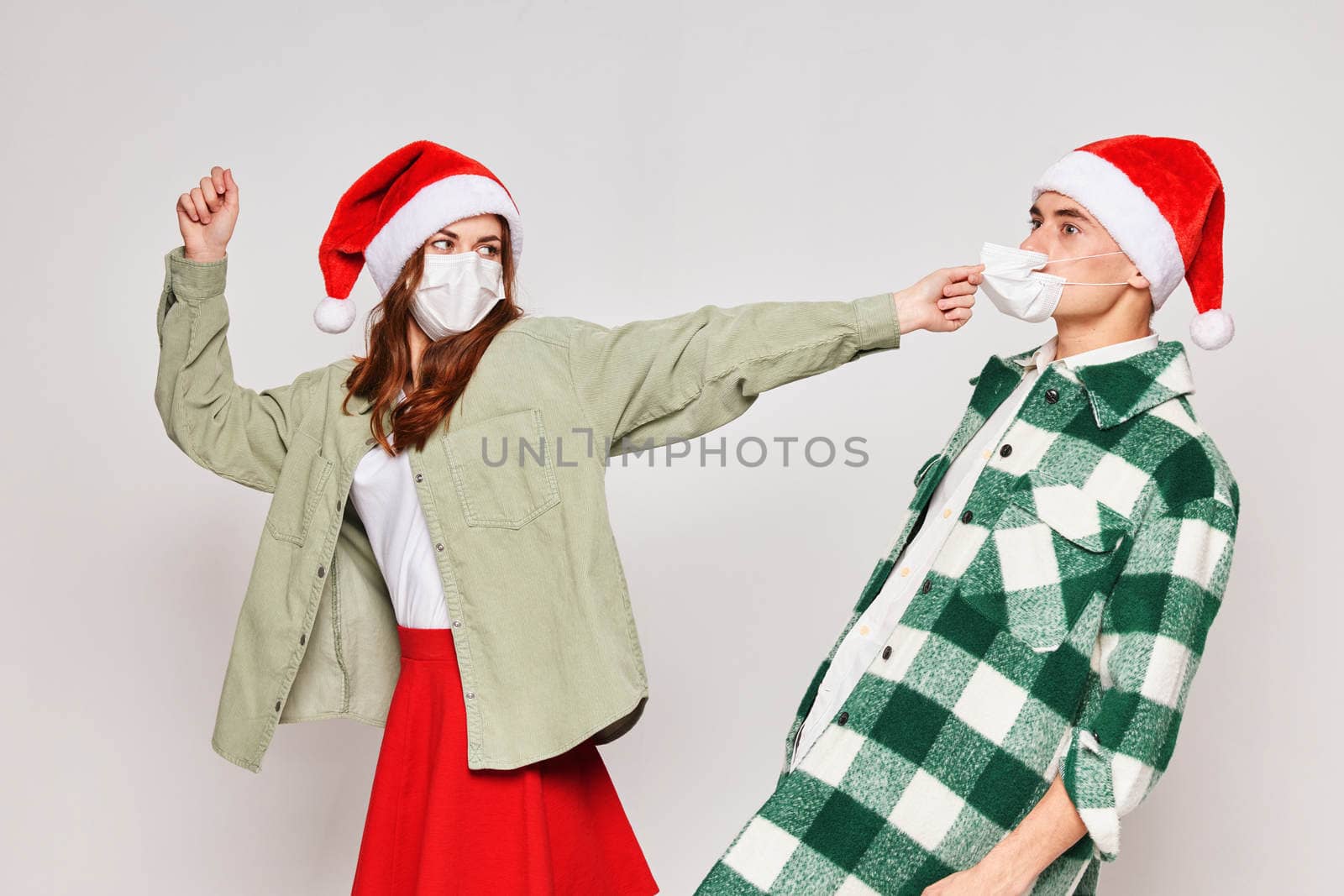man and woman wearing medical masks new year studio holiday christmas. High quality photo
