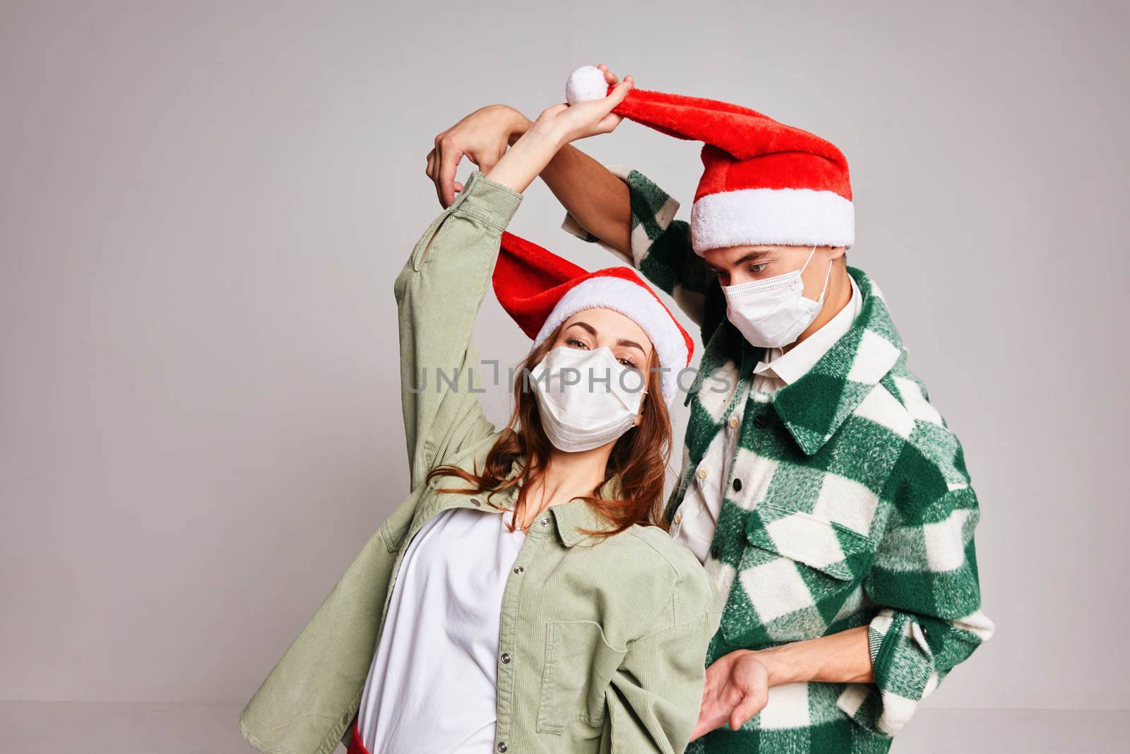 Man and woman having fun together in medical masks holiday Christmas gray background by SHOTPRIME