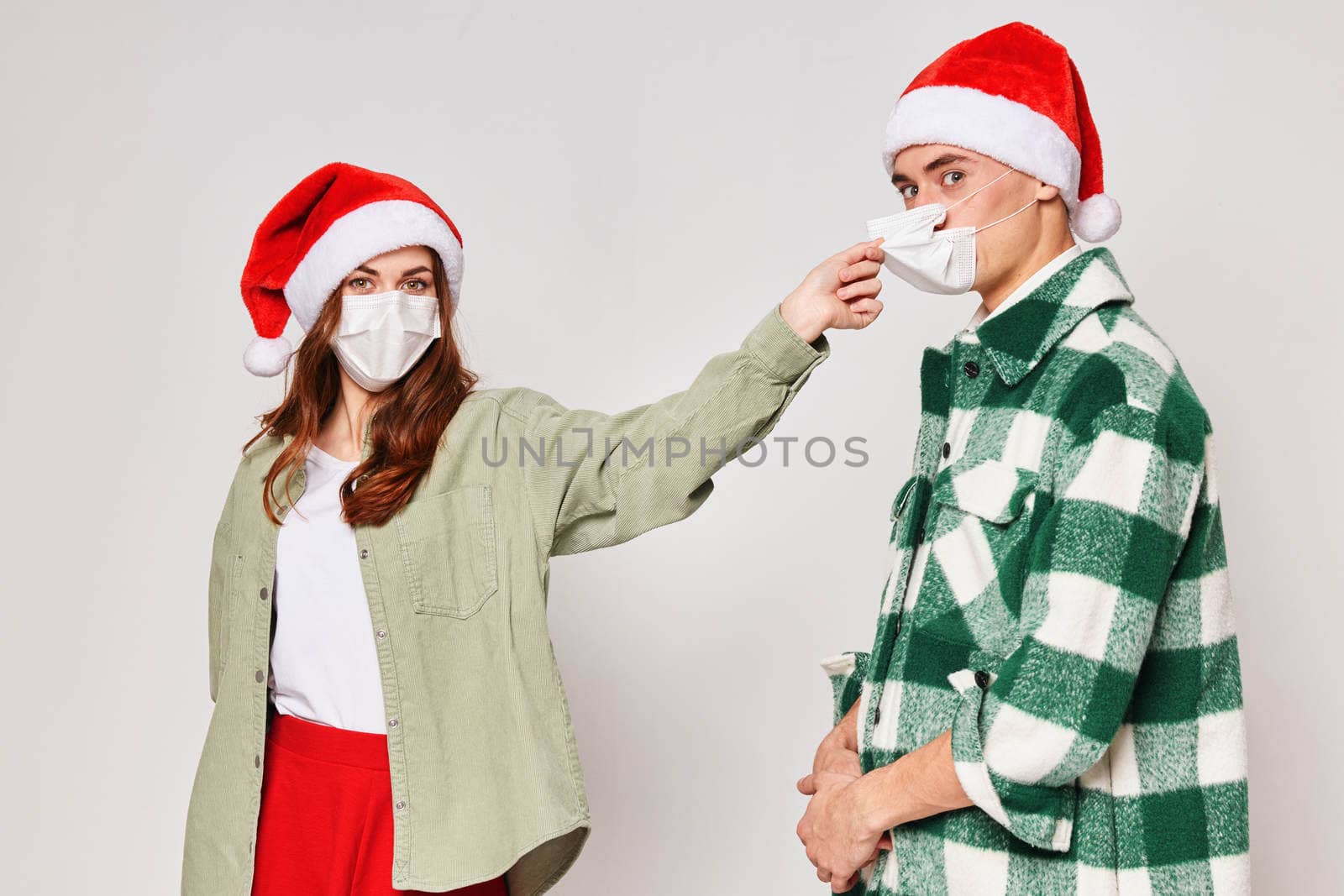 young couple wearing medical masks protecting new year holiday together by SHOTPRIME